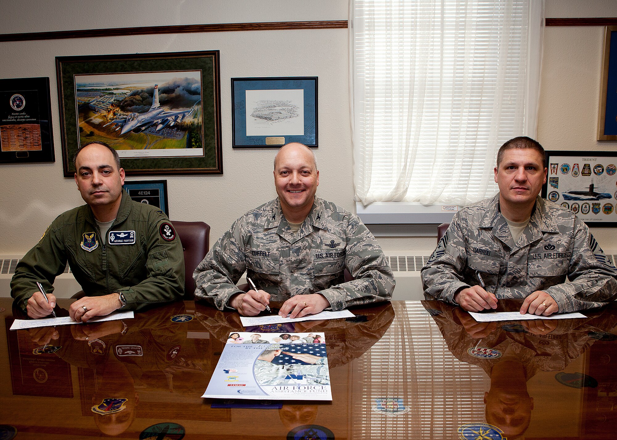 Col. Christopher Coffelt, 90th Missile Wing commander; Col. George Farfour, 90th MW vice commander; and Chief Master Sgt. Michael Garrou, 90th MW command chief, fill out Air Force Assistance Fund forms Feb. 14 in the 90th MW Headquarters. (U.S. Air Force photo by Matt Bilden)