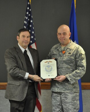 Tech. Sgt. John Fender, 90th Missile Wing Plans and Programs, and Barry Kistler, 90th MW director of staff, hold Fender’s Air Force Combat Action Medal citation Feb. 14 in the Wing Conference Room on F. E. Warren Air Force Base, Wyo. Fender was awarded the AFCAM for “active participation in combat, having been under direct and hostile fire or physically engaging hostile forces with direct and lethal fire, in connection with military operations.” Fender’s actions were in support of Operation Enduring Freedom from Aug. 14, 2004 to March 6, 2005. (U.S. Air Force Photo by Staff Sgt. Torri Savarese)