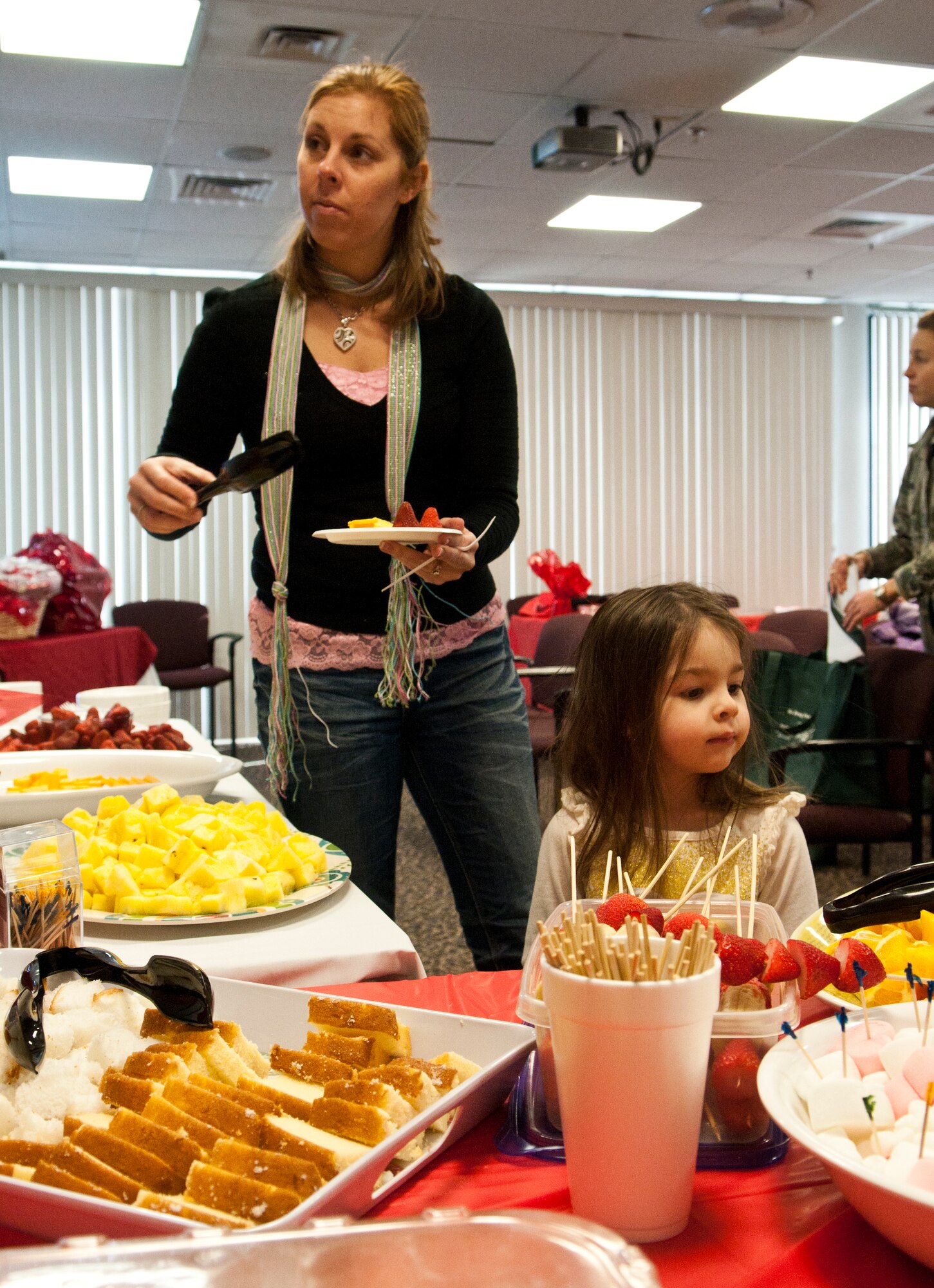 Courtney Hisey, spouse of Staff Sgt. Timothy Hisey, 90th Civil Engineer Squadron, and her daughter, Brooke, help themselves to some of the food provided at the Women’s Heart Health Fair Feb. 14 in the 90th Medical Group Clinic. (U.S. Air Force photo by Airman 1st Class Jason Wiese)