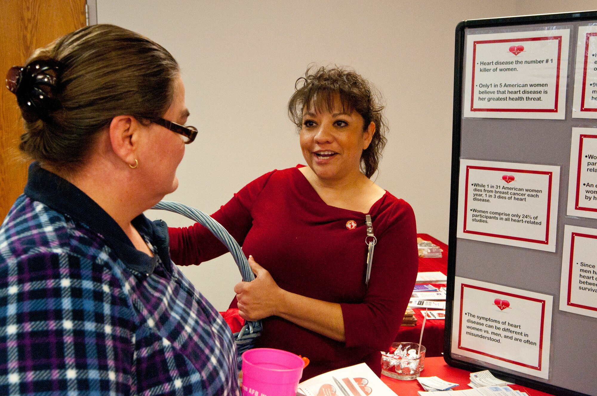 Elizabeth Adams, 90th Medical Group patient safety manager, talks to Susan Lauer, Tricare Service Center, about women’s heart health issues, Feb. 14 in the 90th MDG Clinic. (U.S. Air Force photo by Airman 1st Class Jason Wiese)