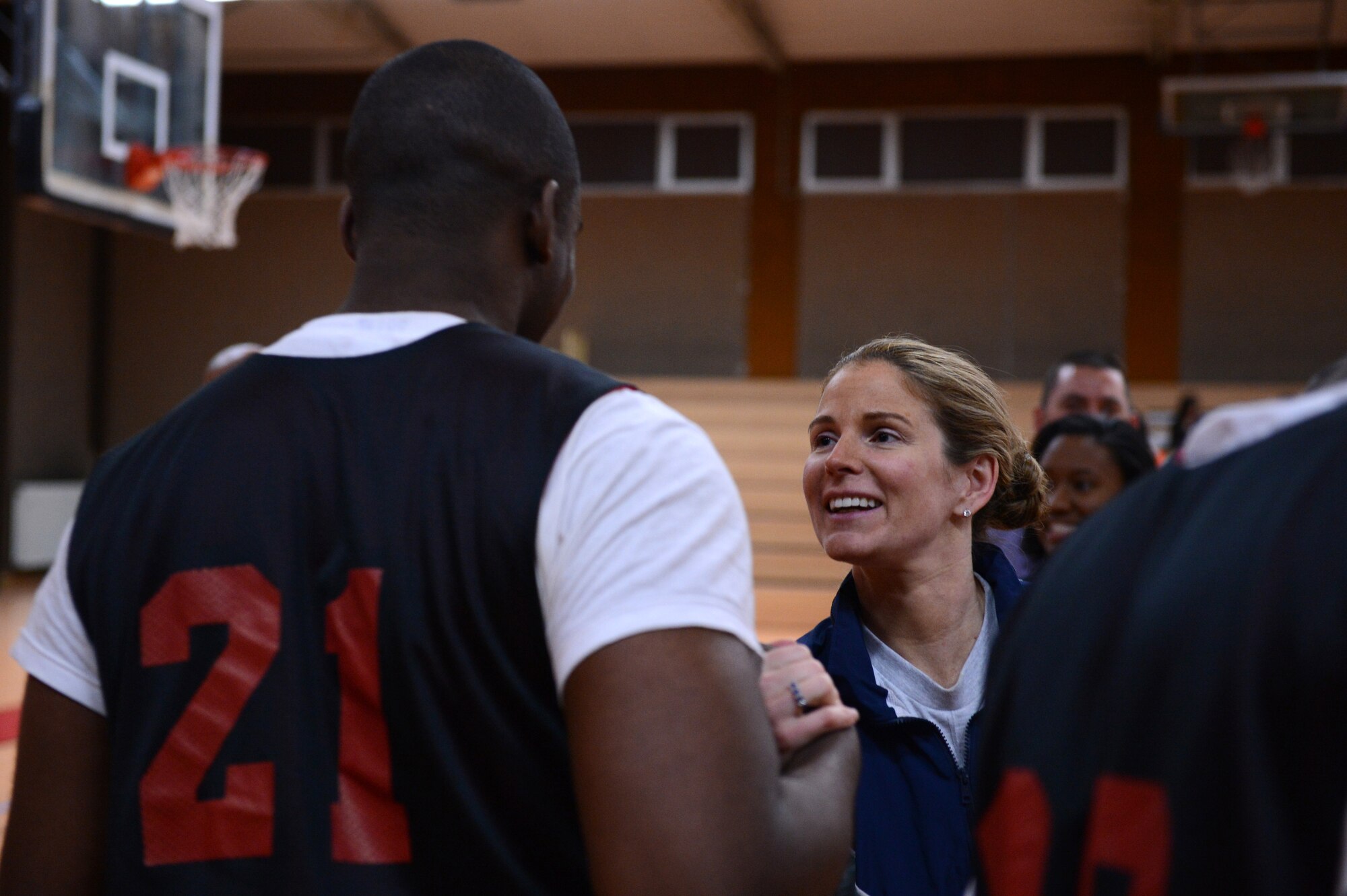 SPANGDAHLEM AIR BASE, Germany – U.S. Air Force Lt. Col. Catherine Logan, 52nd Force Support Squadron commander, congratulates players from her squadron after their victory Feb. 21, 2013. The 52nd FSS defeated the 52nd Logistics Readiness Squadron 46-41 to claim their second intramural sports championship in a row. The 52nd FSS won the intramural football championship last winter. (U.S. Air Force photo by Staff Sgt. Nathanael Callon/Released)