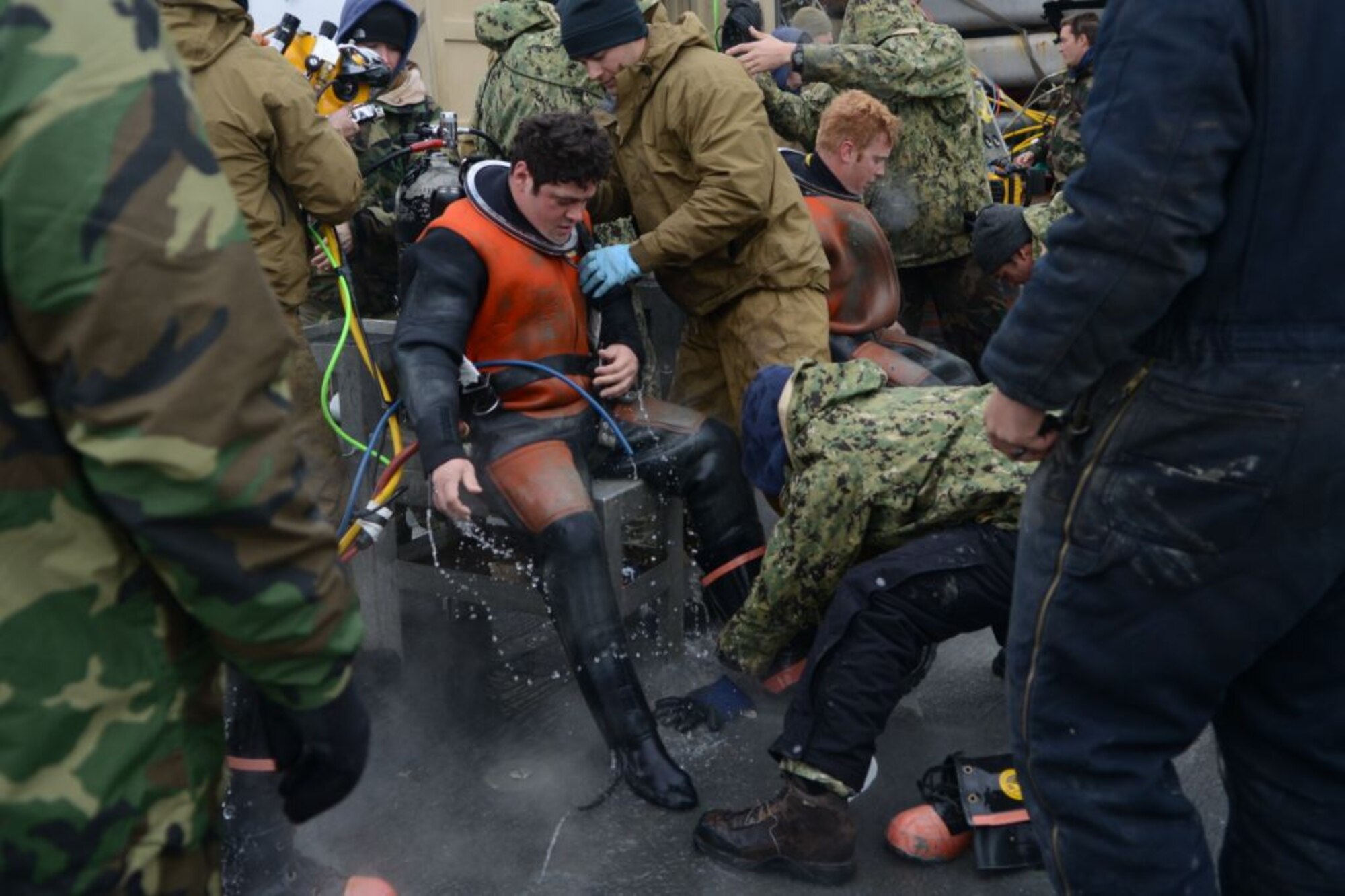 Navy Diver 2nd Class Allen Dewitt, center, prepares to enter a decompression chamber after completing a dive on Feb. 14, 2013.  Navy divers from the Mobile Diving Salvage Unit 2, Company 4, are performing deep sea salvage operations from the salvage vessel USNS Grapple (T-ARS 53) to help find wreckage from an F-16 Fighting Falcon which crashed in the Adriatic Sea, Jan. 28.  (U.S. Air Force photo by Staff Sgt. Evelyn Chavez/Released) 