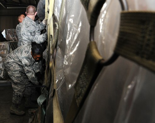 100th Logistics Readiness Squadron Mobility Readiness Spares Package shop members work together to net a pallet of cargo Feb. 19, 2013, at RAF Mildenhall, England. The MRSP is a part of the 100th LRS Material Management Flight. (U.S. Air Force photo by Gina Randall/Released)