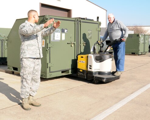 Staff Sgt. Joshua Governal, left, 100th Logistics Readiness Squadron Mobility Readiness Spares Package supervisor from Killeen, Texas, spots while Brian Lilly, 100th LRS skill-level-two storeman, moves a storage container  Feb. 19, 2013, at RAF Mildenhall, England. The MRSP’s personnel inventory, replenish, and prepare parts to deploy from a home station to other locations. (U.S. Air Force photo by Gina Randall/Released)