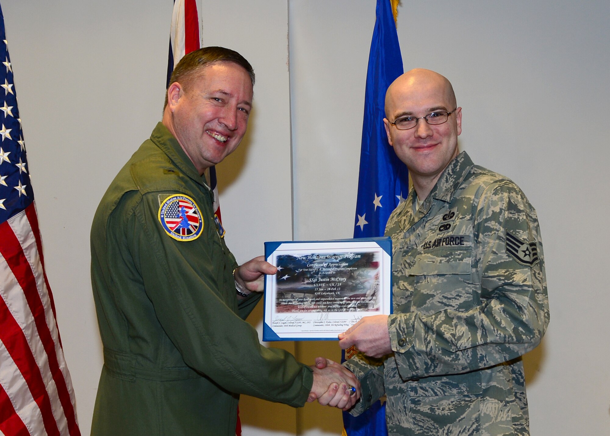 Brig. Gen.  Jon Norman, Director to U.S. Air Forces in Europe-United Kingdom, presents a New Horizons graduation certificate to Staff Sgt. Justin McCrary, USAFE-UK International Law, RAF Mildenhall, Feb. 19, 2013, at the Strike Eagle Complex, RAF Lakenheath, England. McCrary was one of 14 Airmen from the 100th Air Refueling Wing and 48th Fighter Wing who graduated from the New Horizons Wounded Warrior Support Program. (U.S. Air Force photo by Staff Sgt. Stephanie Mancha/Released)