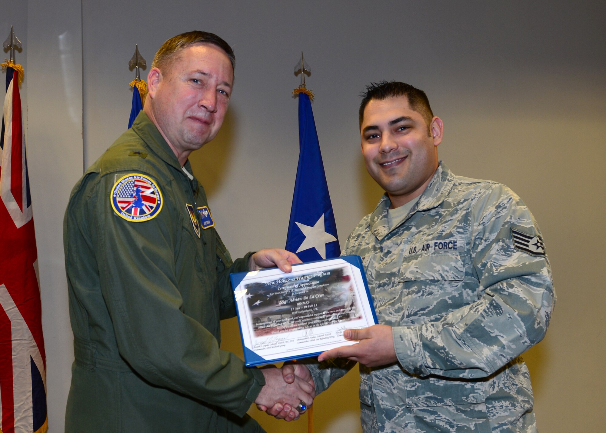 Brig. Gen.  Jon Norman, Director to U.S. Air Forces in Europe-United Kingdom, presents  a New Horizons graduation certificate to Staff Sgt. Adrian De La Cruz, 100th Maintenance Squadron vehicle control NCO from RAF Mildenhall, by Feb. 19, 2013, at the Strike Eagle Complex, RAF Lakenheath, England. De La Cruz was one of 14 Airmen from the 48th Fighter Wing and the 100th Air Refueling Wing who graduated from the New Horizons Wounded Warrior Support Program. (U.S. Air Force photo by Staff Sgt. Stephanie Mancha/Released)