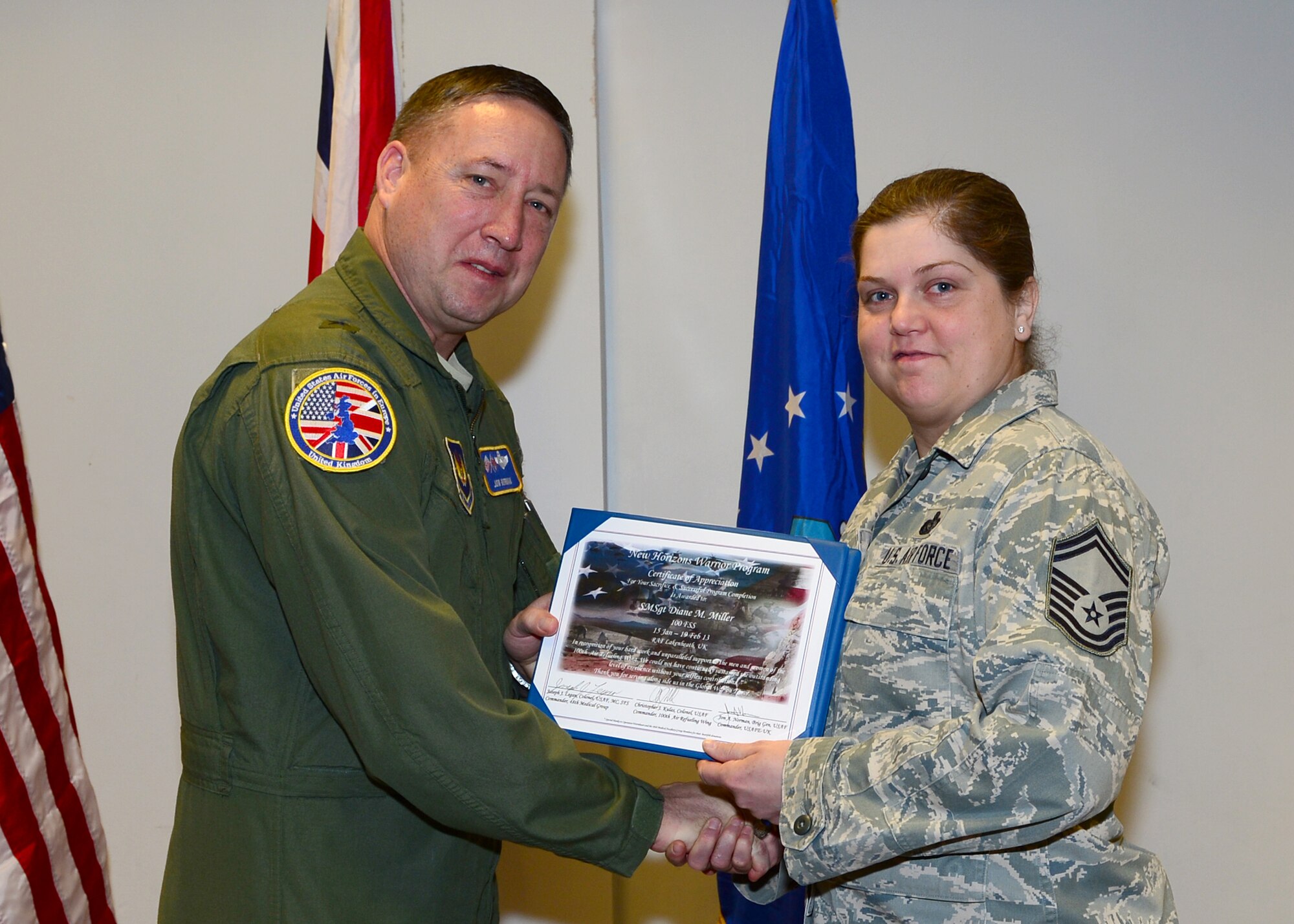 Brig. Gen. Jon Norman, Director to U.S. Air Forces in Europe-United Kingdom, presents a New Horizons graduation certificate to Senior Master Sgt. Diane Miller, 100th Force Support Squadron, RAF Mildenhall, Feb. 19, 2013, at the Strike Eagle Complex, RAF Lakenheath, England. Miller was one of 14 Airmen from the 100th Air Refueling Wing and the 48th Fighter Wing who graduated from the New Horizons Wounded Warrior Support Program. (U.S. Air Force photo by Staff Sgt. Stephanie Mancha/Released)