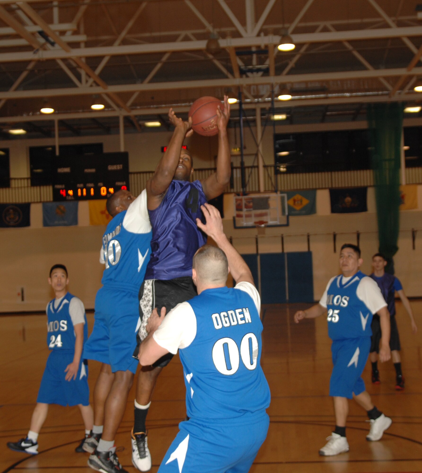Senior Airman Devonte Hentley, 100th Logistics Readiness Squadron vehicle maintenance journeyman from Phoenix, Ariz., jumps to shoot the ball, but is denied by a 100th Maintenance Operations Squadron player during an intramural basketball game between the 100th LRS and 100th MOS Feb. 20, 2013, at the Hardstand Fitness Center on RAF Mildenhall, England. The 100th LRS was victorious over the 100th MOS 45-35. (U.S. Air Force photo by Airman 1st Class Dillon Johnston/Released)