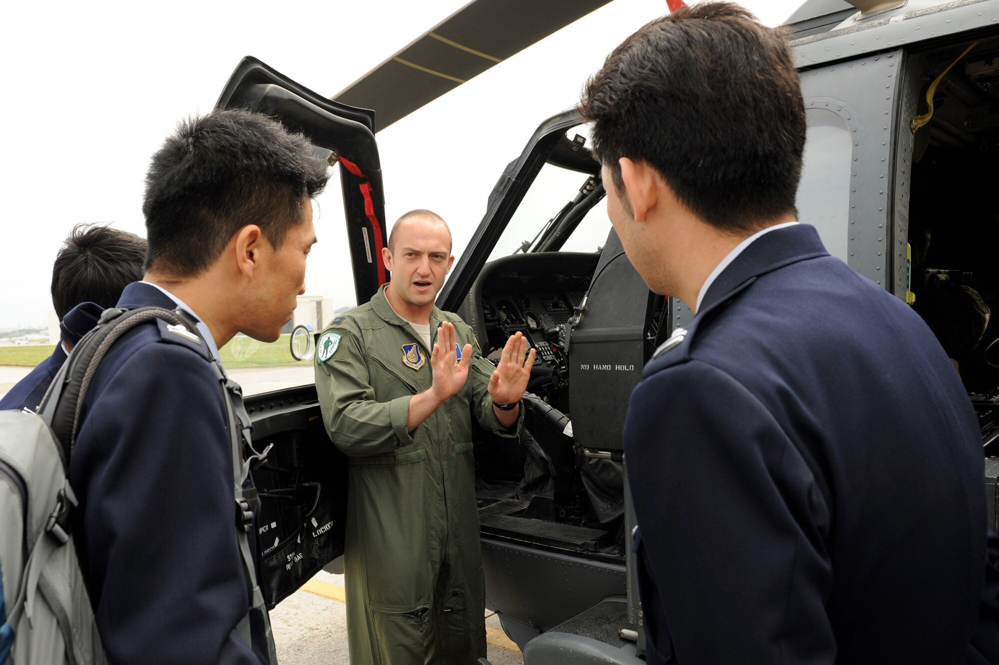 U.S. Air Force Capt. Mark Cerni, 33rd Rescue Squadron pilot, explains how the U.S. Air Force HH-60 Pavehawk helicopter is flown to Japan Air Self-Defense Force personnel during a tour on Kadena Air Base, Japan, Feb. 20, 2013. The JASDF personnel visited the 909th ARS, the 33rd Rescue Squadron and the 961st Airborne Air Control Squadron during their tour of Kadena Air Base. (U.S. Air Force photo/Airman 1st Class Hailey R. Davis)