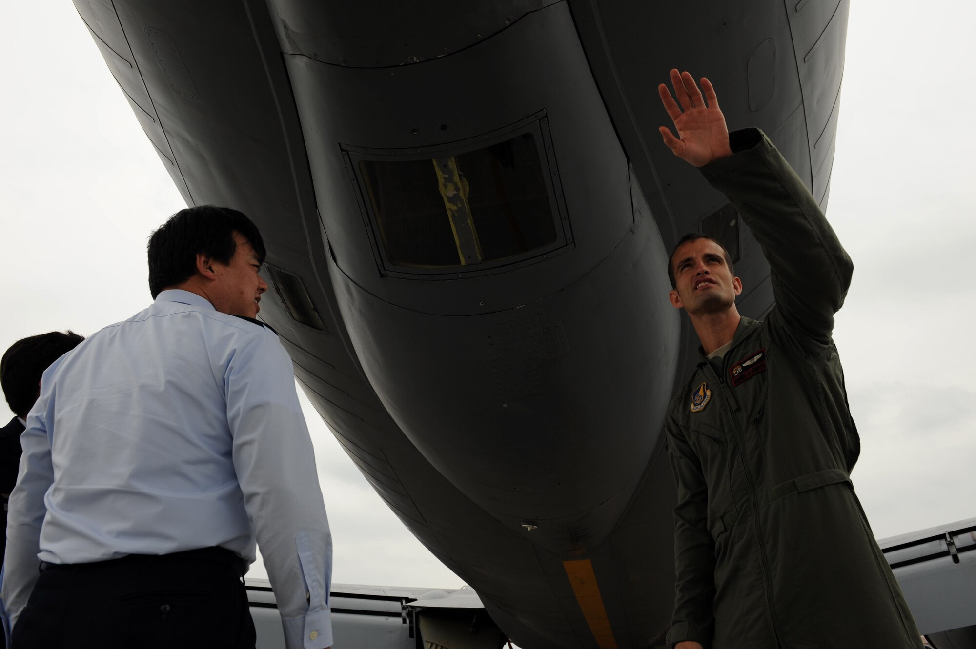 U.S. Air Force Staff Sgt. Brian Porter, 909th Air Refueling Squadron boom operator, explains the role he plays in air refueling to a Japan Air Self-Defense Force officer on Kadena Air Base, Japan, Feb. 20, 2013. JASDF personnel visited the 909th ARS, the 33rd Rescue Squadron and the 961st Airborne Air Control Squadron during their tour of Kadena Air Base. (U.S. Air Force photo/Airman 1st Class Hailey R. Davis)
