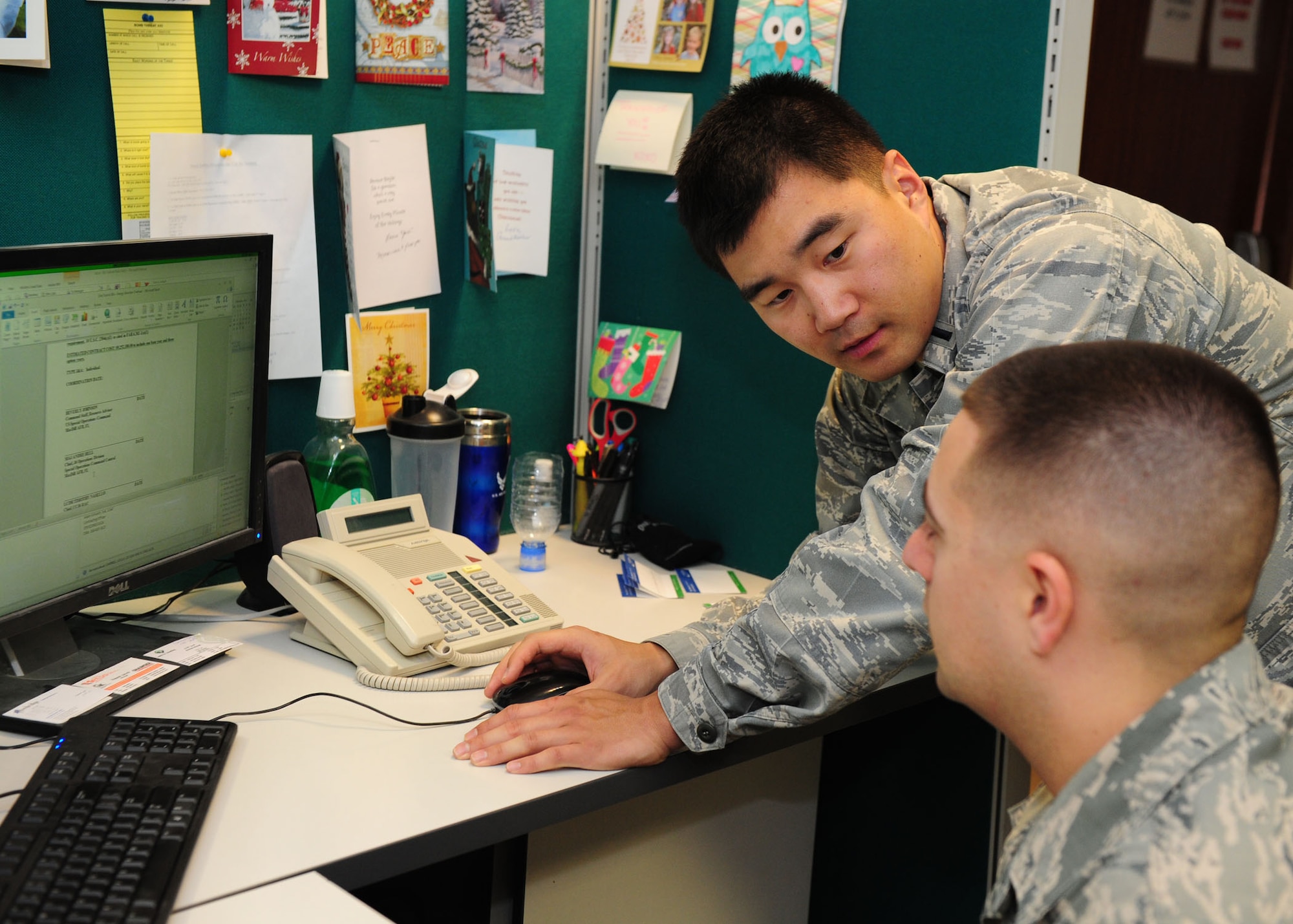 SOUTHWEST ASIA -- 1st Lt. David Won, 379th Expeditionary Contracting Squadron, Base Support Flight commander, discusses justification and approval for a sole source purchase with Senior Airman Adam Gilreath, a 379th ECONS contracting officer. Contracting officers are unique because they deploy with a contingency warrant allowing them to act on and obligate on the U.S. government's behalf. (U.S. Air Force photo/ Master Sgt. Brendan Kavanaugh)