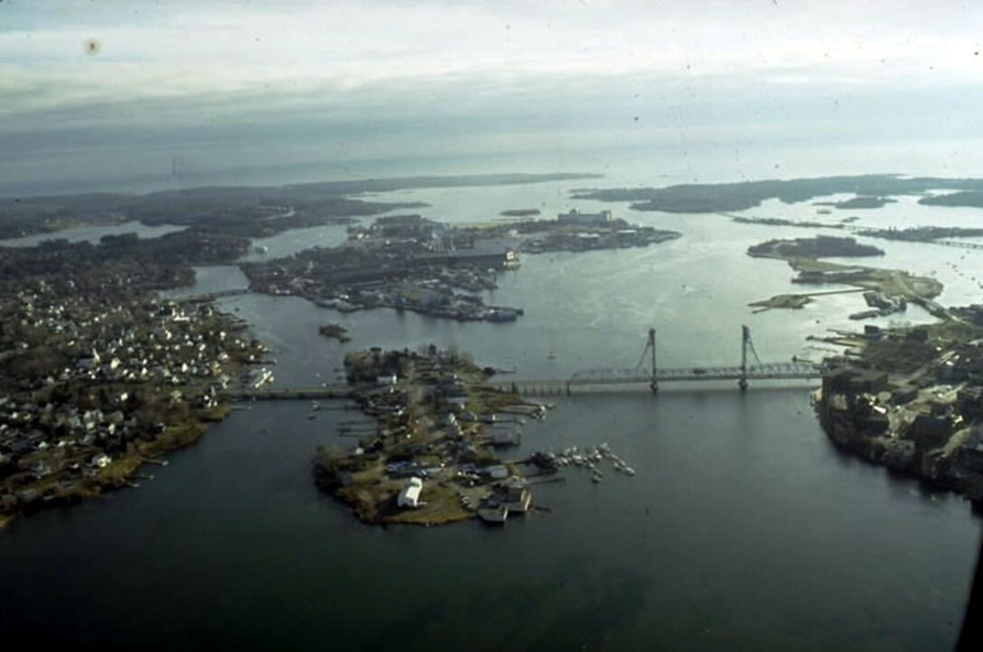 Aerial view of Portsmouth Harbor. Portsmouth Harbor is located on the Piscataqua River, which makes up a portion of the Maine-New Hampshire border. Portsmouth Harbor stretches across the communities of Kittery and Eliot, Maine, and Portsmouth, Newington, and New Castle, New Hampshire. 
