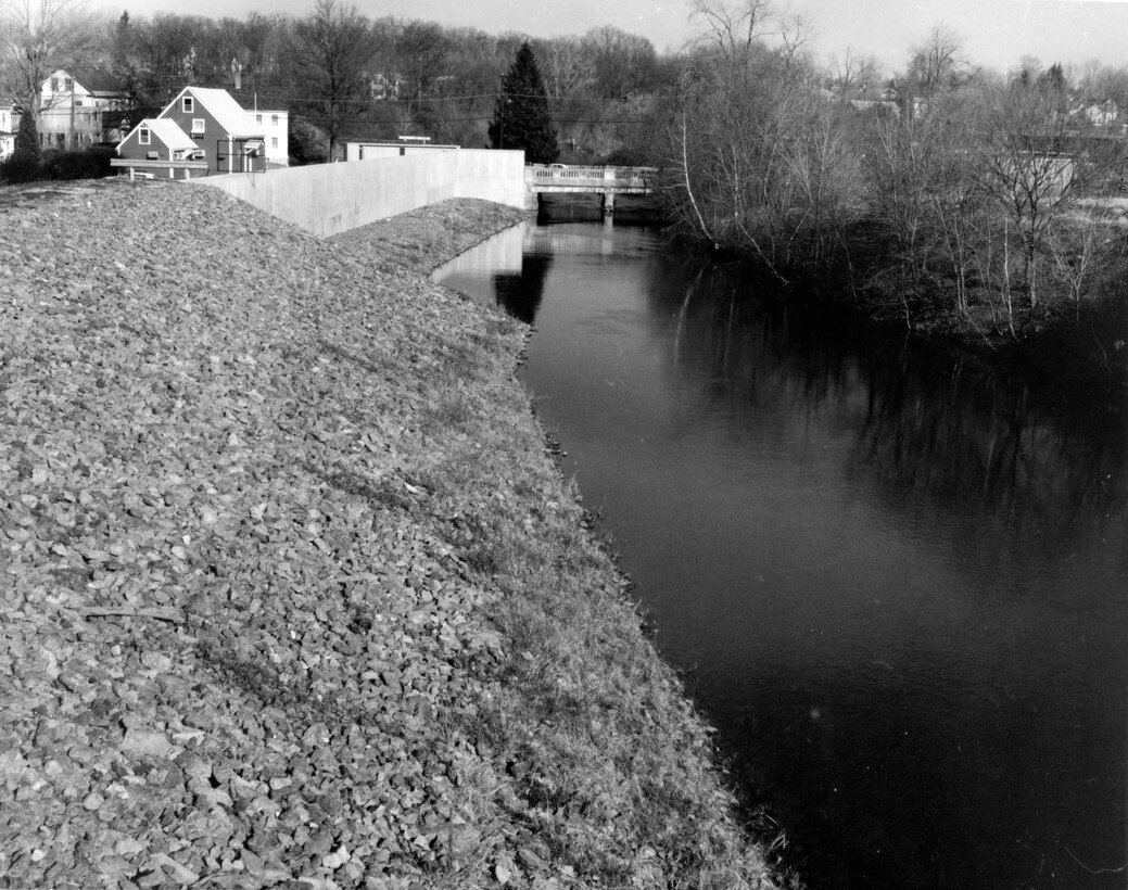 Saxonville LPP. Downstream view of sudbury river on left bank showing dike and concrete flood wall. Concord street bridge is in the background. Located along the Sudbury river, MA