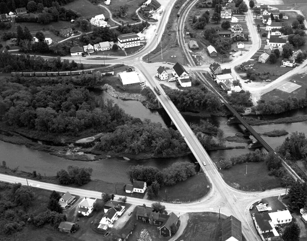 Aerial view of North Stratford Shore and Bank Protection. This project, located in the North Stratford section of Stratford, is situated along the left bank of the Connecticut River, adjacent to the Bloomfield (Vermont) - North Stratford Bridge on Route 105 and the town's fire station. The project is about 20 miles south in NH of the Canadian border. Photo was taken in June 1989.