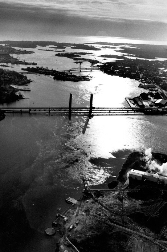 Aerial view of Portsmouth Harbor Navigation Project.  Formed by the confluence of the Salmon Falls and Cocheco rivers, the Piscataqua River originates at the boundary of Dover, New Hampshire, and Eliot, Maine, and flows southeasterly for 13 miles to Portsmouth Harbor, comprising a partial border between the two states. The last 8.8 miles of the Piscataqua River constitute Portsmouth Harbor, which stretches across New Castle, Portsmouth, and Newington, and the Maine communities of Kittery and Eliot. Photo was taken in Dec. 1987.