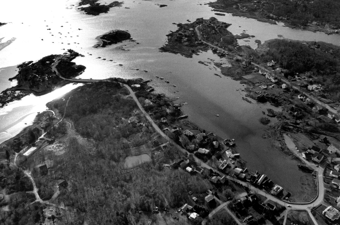 Aerial view of Cape Porpoise Harbor. Cape Porpoise Harbor is located in the Cape Porpoise section of Kennebunkport, ME about 27 miles southwest of Portland. The harbor consists of three coves indenting the shore of Cape Porpoise, an active lobstering center with large fishing and recreational fleets. The town wharf is located on Bickford Island, which is connected by a causeway to Cape Porpoise. Photograph taken Dec. 1987.