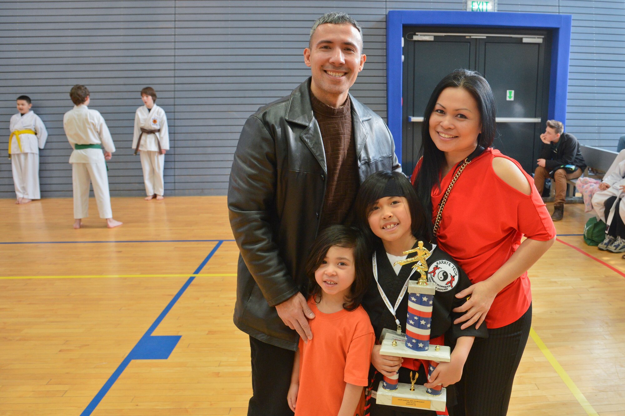 Jaeden Hose, 8, son of Master Sgt. Mathew Hose, 521st Air Mobility Operations Wing Air Force Smart Operations for the 21st century program manager, stands next to his family after finishing first in the 13th annual U.S. Air Forces in Europe and Air Forces Africa Martial Arts Tournament on Ramstein Air Base, Germany, Feb. 23, 2013. The USAFE-AFAFRICA Martial Arts Tournament is a way for all participants ages 3 to 18 to test their martial art skills against their peers. (U.S. Air Force photo/Airman 1st Class Jordan Castelan)