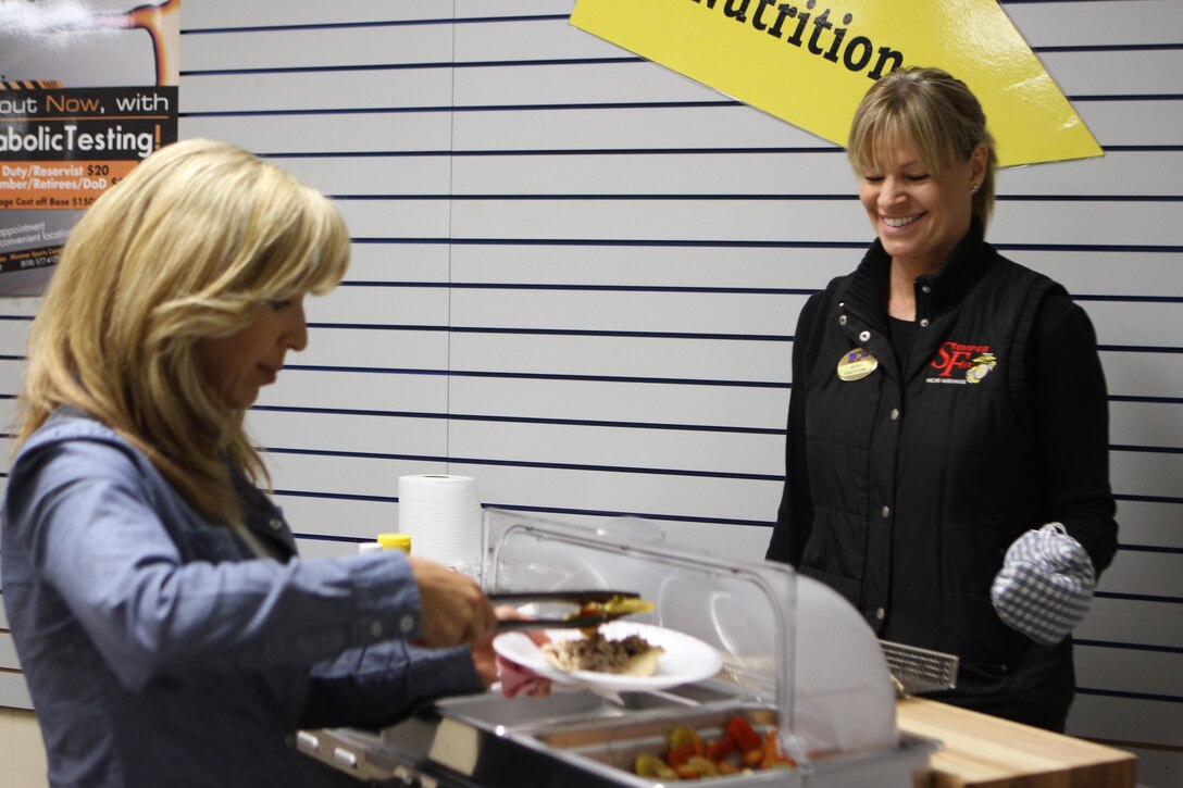 Tracy Turner (left), a class participant and a San Diego native, samples some food from a new warming tray during Julie’s Supper Club at the High Intensity Interval Training conference room aboard Marine Corps Air Station Miramar, Calif., Feb. 20. Julie’s Supper Club is a new healthy cooking class that focuses on preparing healthy dishes that are also tasty.  