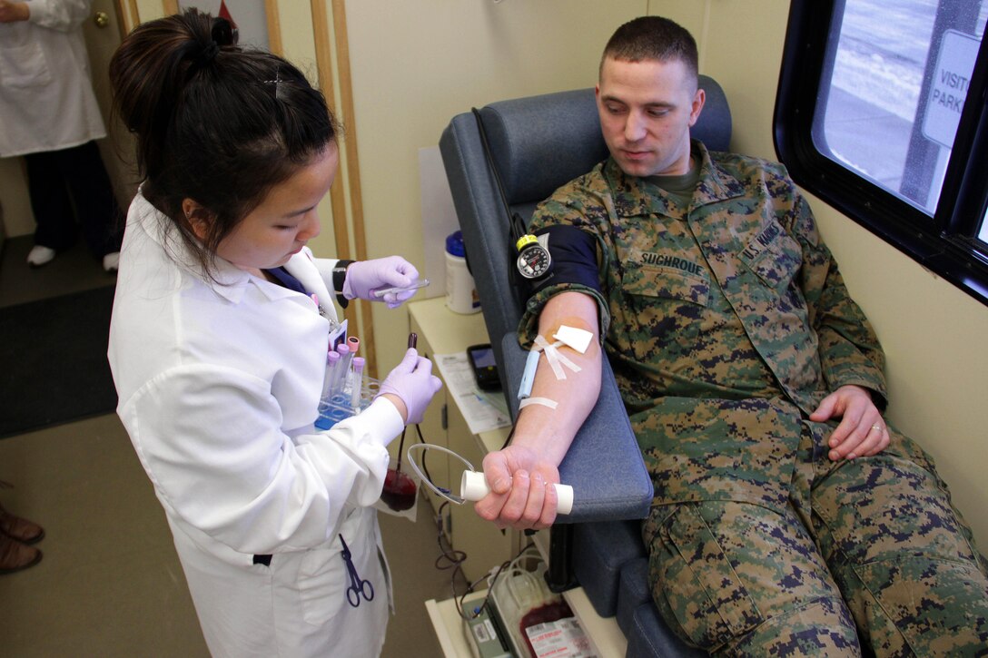 Mai Xiong draws blood from Sgt. Seth Sughroue, 26, from McCook, Neb., during his quarterly donation Feb. 13. Sughroue is the administration clerk for Recruiting Station Twin Cities. He strives to donate whenever he sees the Mobile Memorial Blood Center parked outside of his office.  