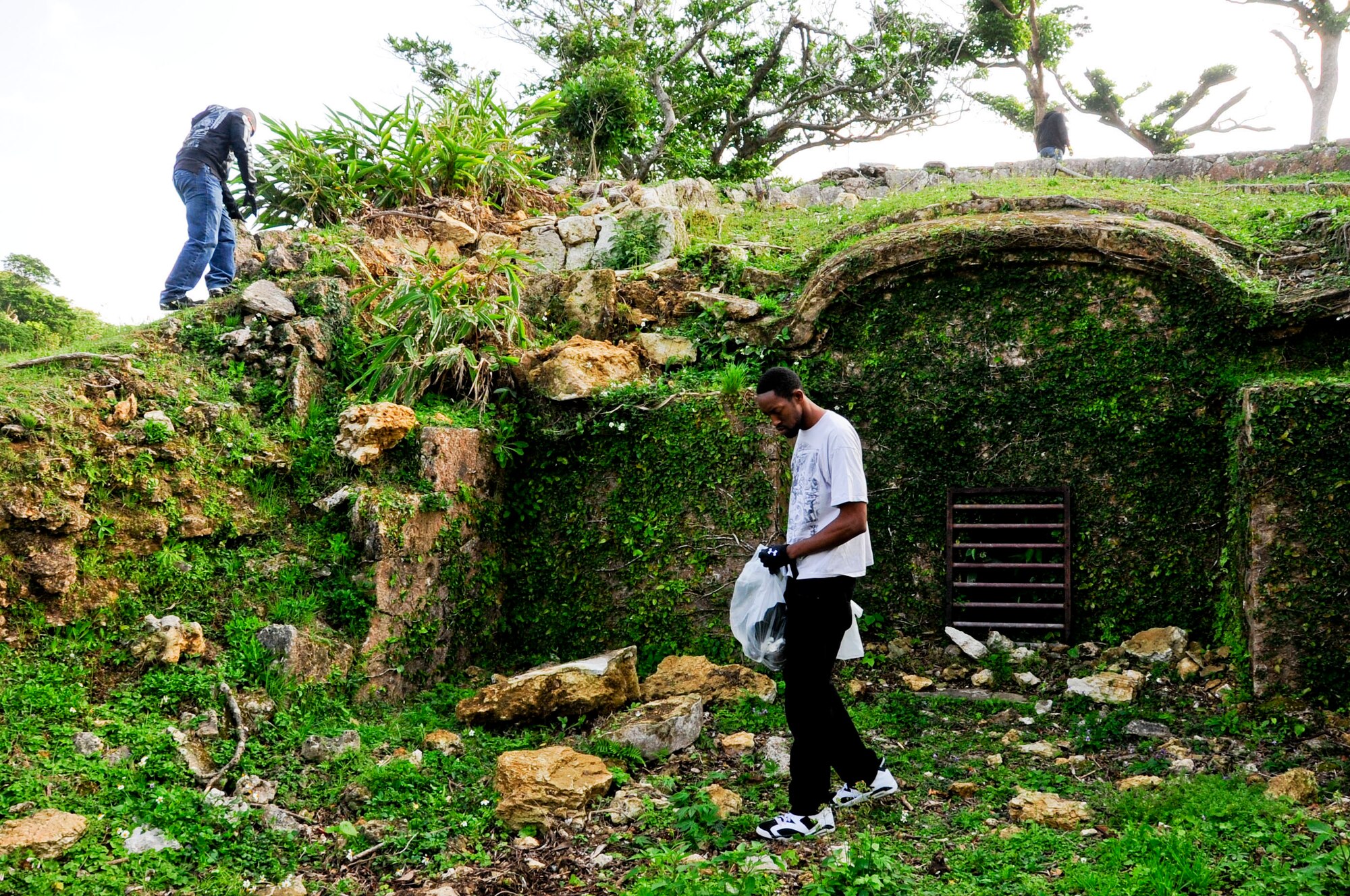 U.S. Air Force Staff Sgt. Carlos Fernandez (above), 18th Component Maintenance Squadron aerospace propulsion journeyman, and Senior Airman Andre Ingram (right), 18th CMS aerospace propulsion apprentice,  pick up debris during a historical site clean-up at the Kadena Marina, Japan, Feb. 25, 2013. Thirteen historical sites across Kadena Air Base and the marina were cleaned. (U.S. Air Force photo/Staff Sgt. Darnell T. Cannady)