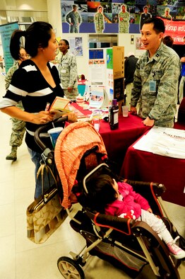 Maria Teichmann, military spouse, receives information for her daughter, Lydia Teichmann, from U.S. Air Force Capt. Chung Tsen, 18th Medical Group general dentist, during a Joint Services Health Promotion Fair at the Exchange on Kadena Air Base, Japan, Feb. 21, 2013. The dental booth informed people about the proper ways of brushing teeth and flossing and provided dental information for children. The 10-booth health fair was the first joint service effort between Kadena and Camp Lester and provided information on programs including dental, alcohol and drug abuse prevention and treatment and disease management. (U.S. Air Force photo/Staff Sgt. Darnell T. Cannady)