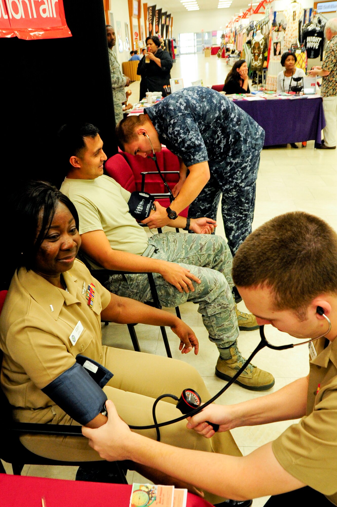 U.S. Navy Seaman Zachary Midcalf (front) and Petty Officer 3rd Class Michael Matthews (back), both assigned to U.S. Naval Hospital Okinawa preventive medicine technicians, check the blood pressure of people during the Joint Services Health Promotion Fair at the Exchange on Kadena Air Base, Japan, Feb. 21, 2013. The booths promoted knowing blood pressure levels, safe levels of blood pressure and provided information for anyone with high blood pressure.  The health fair was the first joint service effort between Kadena and Camp Lester. (U.S. Air Force photo/Staff Sgt. Darnell T. Cannady)
