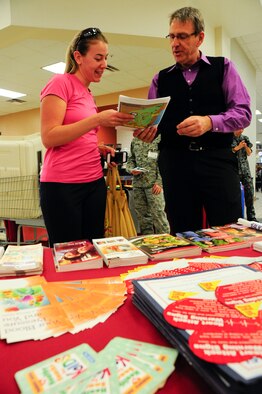 Jamie Alberti, military spouse, receives hospital information about U.S. Naval Hospital Okinawa from Brian Davis, USNHO Public Affairs officer, during a Joint Services Health Promotion Fair at the Exchange on Kadena Air Base, Japan, Feb. 21, 2013. Davis informed visitors that the hospital on Camp Lester is moving to Camp Foster, the timeline for the move, and provided them a map to show where it will be located on Camp Foster. (U.S. Air Force photo/Staff Sgt. Darnell T. Cannady)