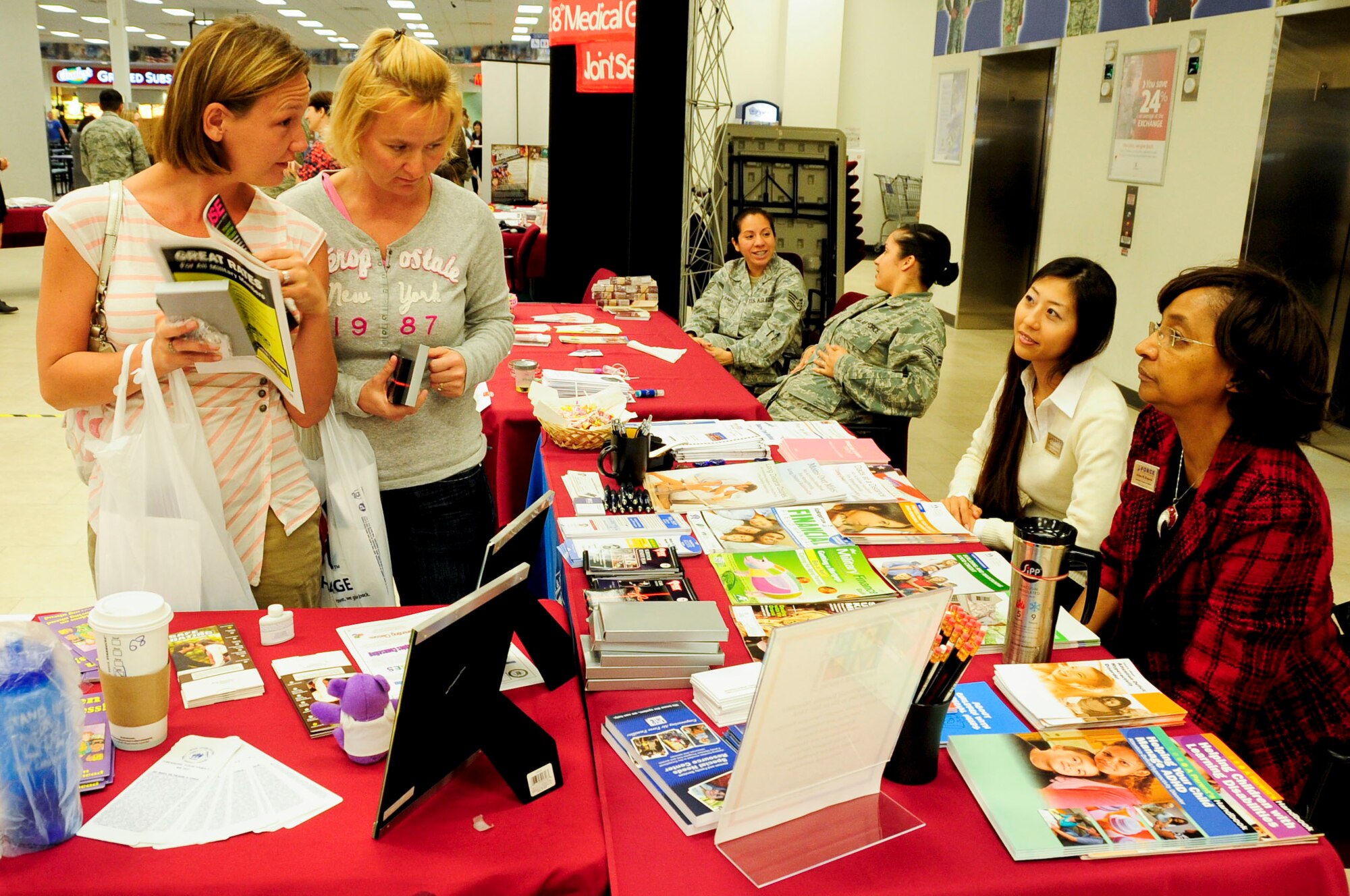Kimberly McClary, Army spouse, and Angie Utley, Air Force spouse, speak with Arlyne Rzepecki, 18th Force Support Squadron Airman and family readiness center community relation consultant, and Nanako Misato, 18th FSS intercultural coordinator, during a Joint Services Health Promotion Fair at  the Exchange on Kadena Air Base, Japan Feb. 21, 2013. The AFRC provides service members and their spouses information about finance, transitioning into or out of Kadena, employment, volunteer opportunities, relocation, family life programs and deployment classes. They also provide cultural classes for international marriages where they introduce Japanese spouses to military lifestyle, and give basic Japanese language and kimono-wearing classes. (U.S. Air Force photo/Staff Sgt. Darnell T. Cannady)