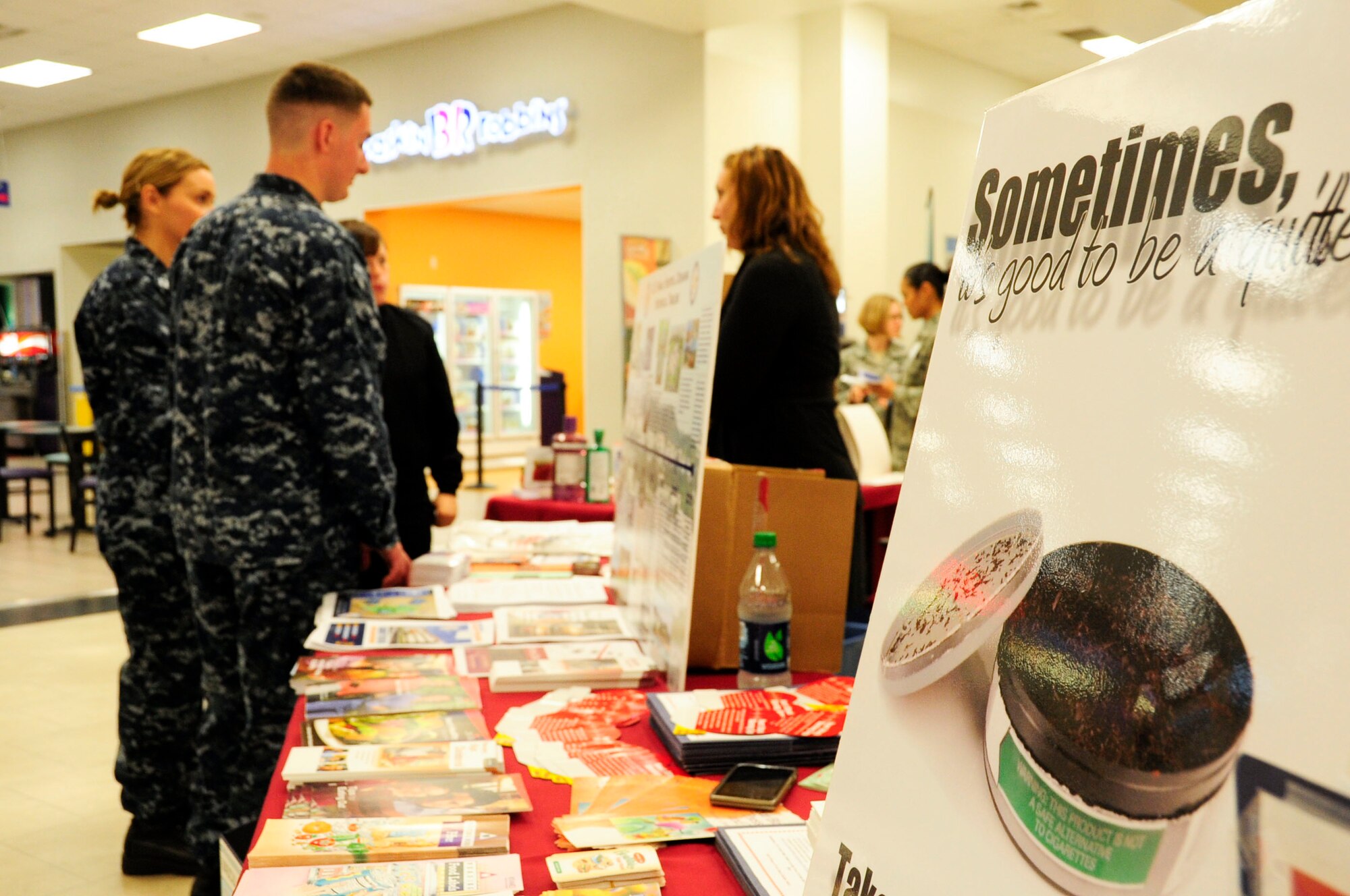 Christie Cornell, 18th Medical Group Health and Wellness Center health promotion coordinator, informs U.S. Navy Seaman Warren Delong, U.S. Naval Hospital Okinawa corpsman, and Lt. Melissa Slack, USNHO staff nurse, about the benefits of giving up tobacco during a Joint Services Health Promotion Fair at the Exchange on Kadena Air Base, Japan, Feb. 21, 2013. The Great American Spit Out, Feb. 18-22, encouraged members to quit tobacco by offering classes and educating members on the medication available to quit tobacco use. (U.S. Air Force photo/Staff Sgt. Darnell T. Cannady)