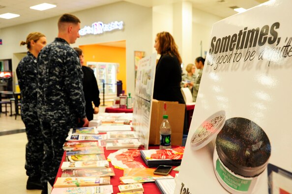 Christie Cornell, 18th Medical Group Health and Wellness Center health promotion coordinator, informs U.S. Navy Seaman Warren Delong, U.S. Naval Hospital Okinawa corpsman, and Lt. Melissa Slack, USNHO staff nurse, about the benefits of giving up tobacco during a Joint Services Health Promotion Fair at the Exchange on Kadena Air Base, Japan, Feb. 21, 2013. The Great American Spit Out, Feb. 18-22, encouraged members to quit tobacco by offering classes and educating members on the medication available to quit tobacco use. (U.S. Air Force photo/Staff Sgt. Darnell T. Cannady)