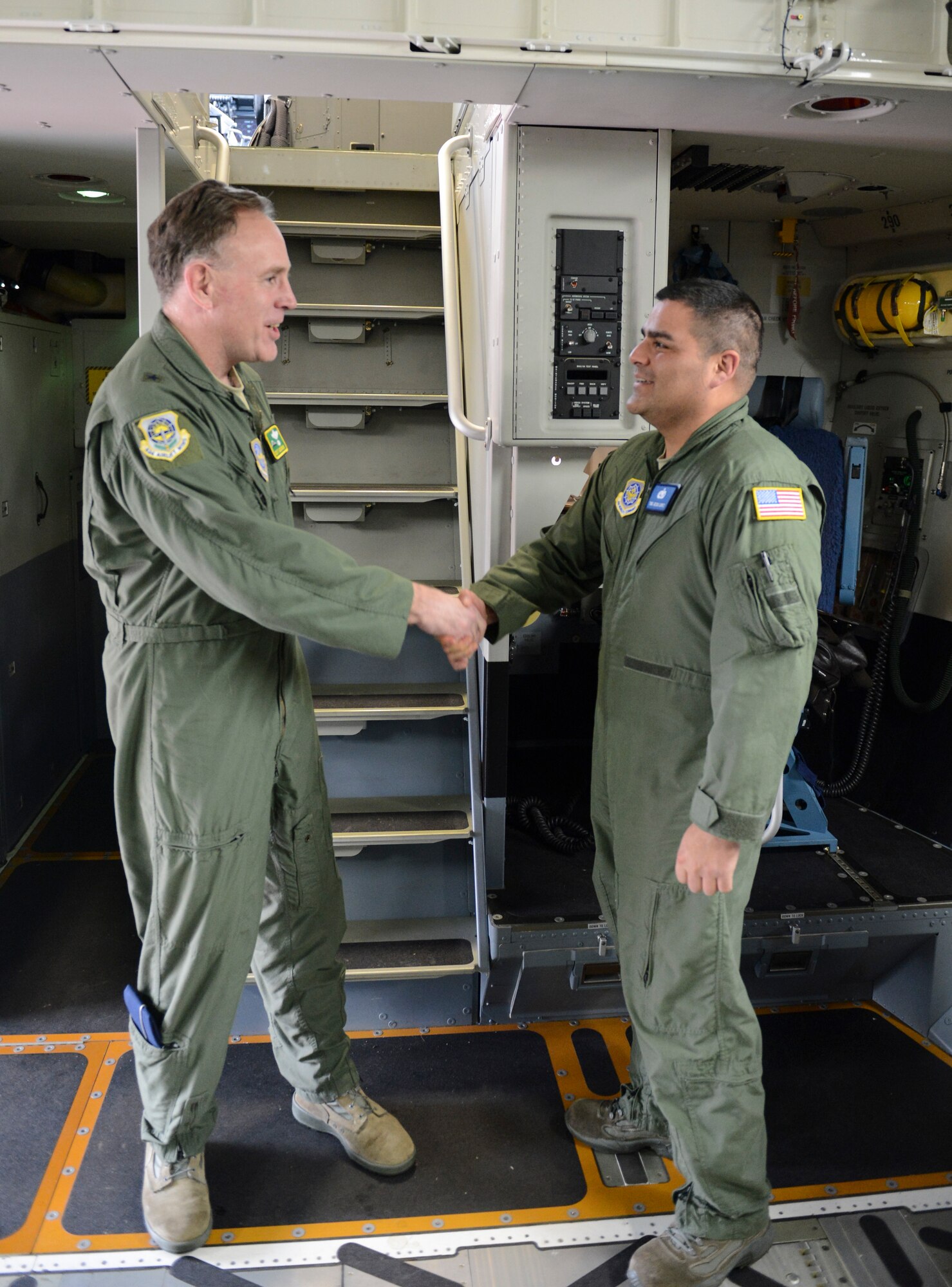 Brig. Gen. Scott Goodwin, Air Mobility Command director of operations (left), hands the “keys” to McChord Field's newest C-17 Globemaster III aircraft to Tech. Sgt. Jesus Lopez, 62nd Aircraft Maintenance Squadron flying crew chief (right), Feb. 20, 2013, soon after landing the aircraft at Joint Base Lewis-McChord, Wash. Goodwin, the aircraft’s delivery official, piloted the new jet from Long Beach, Calif., to McChord Field. (U.S. Air Force photo/Tech. Sgt. Sean Tobin)