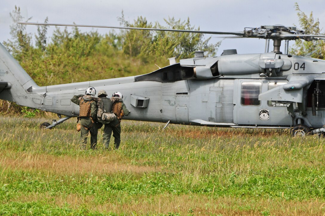 Flightcrew members from the Helicopter Sea Combat Squadron 25 carry a Soldier from the 1st Battalion, 294th Infantry Regiment, Guam Army National Guard, with a simulated injury during a joint-training exercise at Andersen South, Guam, Feb. 19, 2013. HSC-25 was able to fulfill their training requirements on ground personnel recovery by assisting Guam Army National Guard with their Combat Life Saver course. (U.S. Air Force photo by Airman 1st Class Marianique Santos/Released)