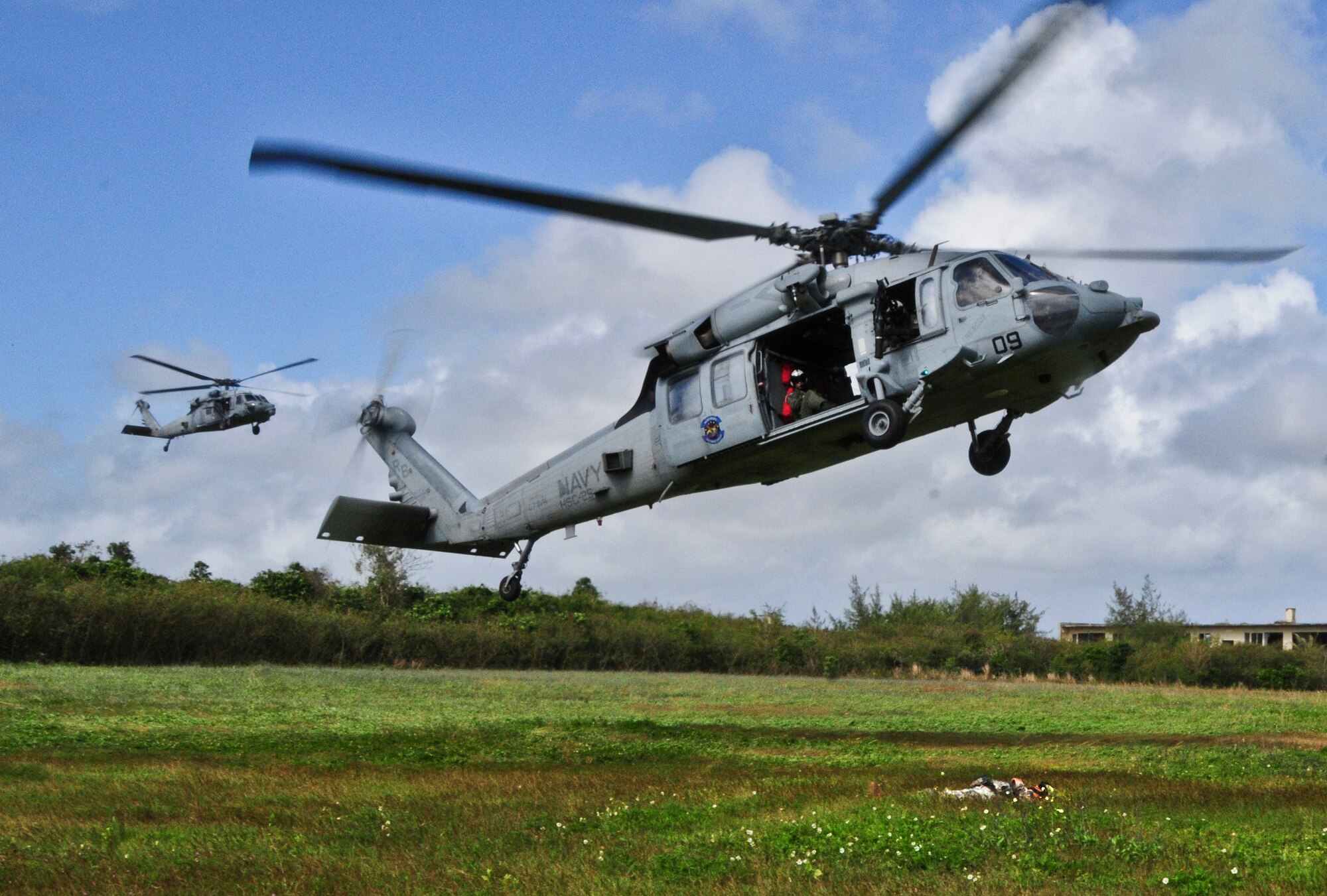 Helicopter Sea Combat Squadron 25 MH-60S Seahawk’s fly toward a patient during a simulated recovery training  with the 1st Battalion, 294th Infantry Regiment, Guam Army National Guard, at Andersen South, Guam, Feb. 19, 2013. HSC-25 was able to fulfill their training requirements on ground personnel recovery by assisting Guam Army National Guard with their Combat Life Saver course.  (U.S. Air Force photo by Airman 1st Class Marianique Santos/Released)