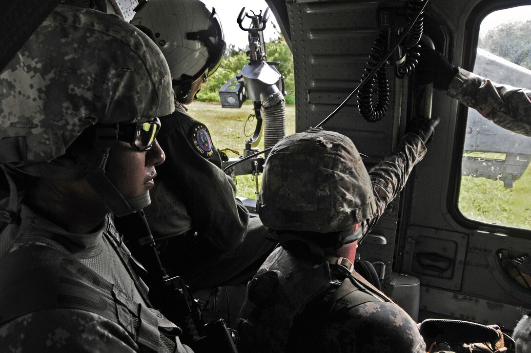 A crewmember from the Helicopter Sea Combat Squadron 25 and Soldiers from the 1st Battalion, 294th Infantry Regiment, Guam Army National Guard, await takeoff during an extraction from a simulated combat zone at Andersen South, Guam, Feb. 19, 2013. HSC-25 was able to fulfill their training requirements on ground personnel recovery while assisting Guam Army National Guard Soldiers with their Combat Life Saver course. (U.S. Air Force photo by Airman 1st Class Marianique Santos/Released)
