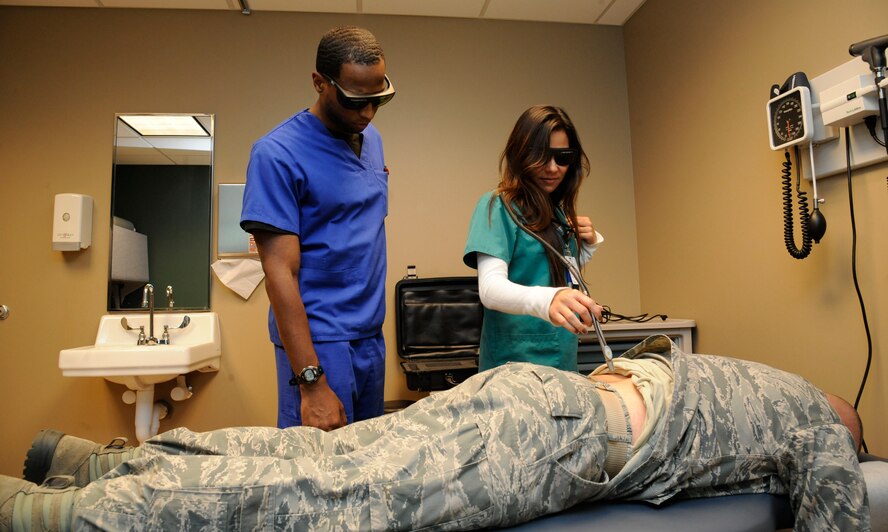 Charlene Staystork, 2nd Medical Group chiropractic technician, and Ronald Howard, orthopedic technician, prepare to use laser therapy on a patient on Barksdale Air Force Base, La., Feb. 25. Laser therapy hastens cell repair and is used as an alternative or additional treatment for patients. (U.S. Air Force photo/Airman 1st Class Andrew Moua)