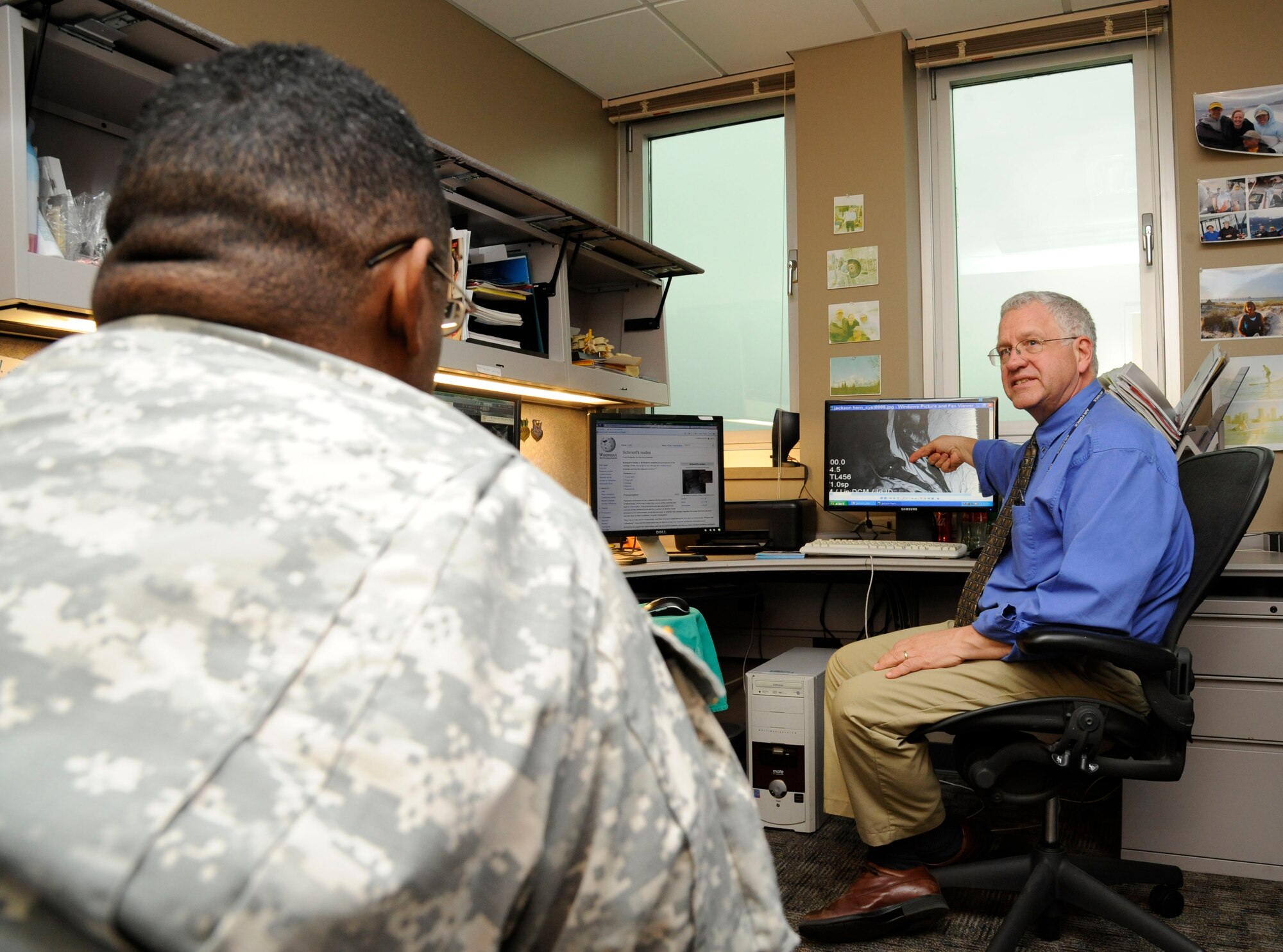 Dr. Philip Hardinger, 2nd Medical Group chiropractor, shows Capt. Dana Capers, U.S. Army Reserves, his X-rays on Barksdale Air Force Base, La., Feb. 25. The chiropractic section of the 2 MDG provides physical therapy for a variety of injuries such as pinched nerves, bulging disks and pain related to the nervous system. (U.S. Air Force photo/Airman 1st Class Andrew Moua)