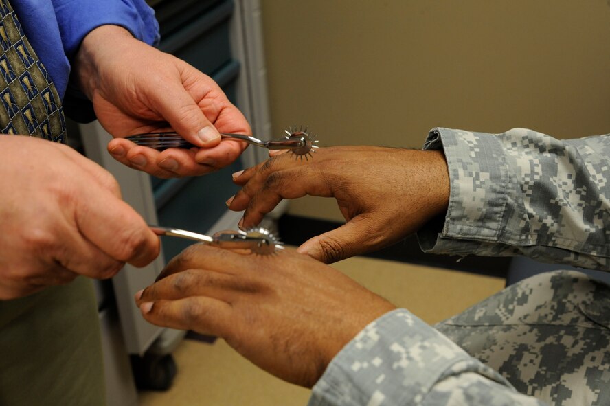 Dr. Philip Hardinger, 2nd Medical Group chiropractor, performs tests on the hands of Capt. Dana Capers, U.S. Army Reserves, on Barksdale Air Force Base, La., Feb. 25. The tools used by Hardinger are used to see if the patient can feel the pins on the skin as an indication of the status of the patient's nerves. (U.S. Air Force photo/Airman 1st Class Andrew Moua)