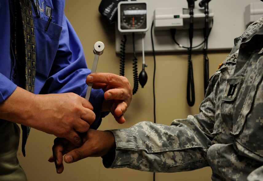 Dr. Philip Hardinger, 2nd Medical Group chiropractor, examines the hands of Capt. Dana Capers, Army Reserves, on Barksdale Air Force Base, La., Feb. 25. Hardinger uses a tool which vibrates to test if the patient's hands are able to feel the sensation. (U.S. Air Force photo/Airman 1st Class Andrew Moua)