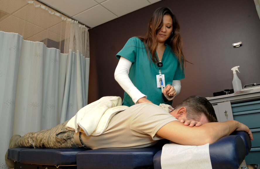 Charlene Staystork, 2nd Medical Group chiropractic technician, prepares Lt. Col. Matt Gorleau, Air Force Global Strike Command, for electro-muscle stimulation treatment on Barksdale Air Force Base, La., Feb. 25. The chiropractic section of the 2 MDG provides physical therapy for a variety of injuries such as pinched nerves, bulging disks and pain related to the nervous system. (U.S. Air Force photo/Airman 1st Class Andrew Moua)