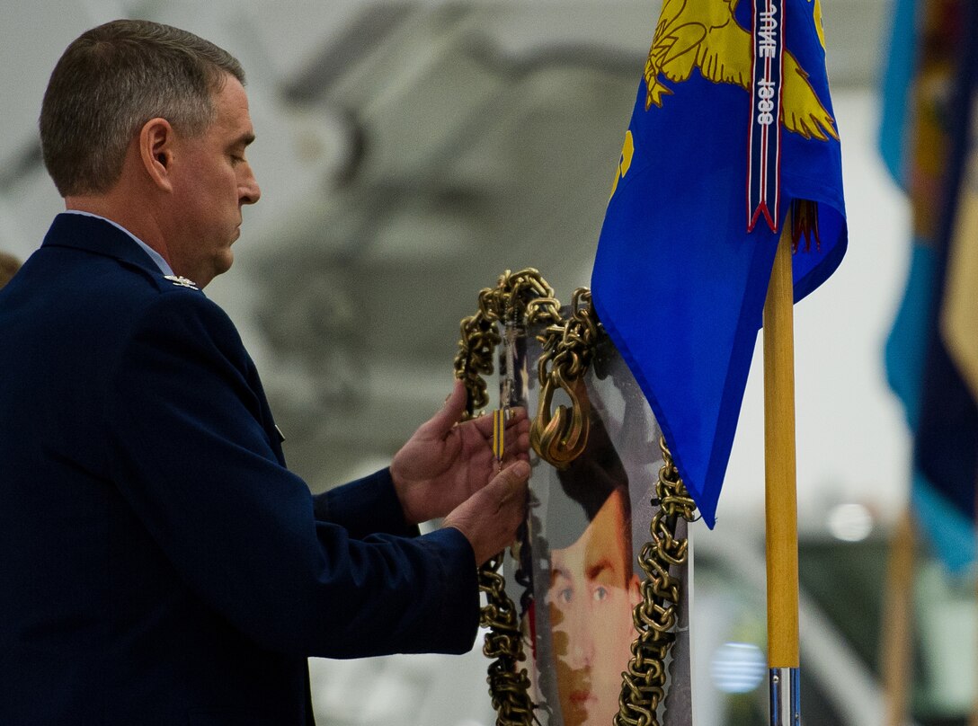 Col. Michael Minihan, 89th Airlift Wing commander, pins an Air Force Commendation Medal on the memorial of the late Senior Airman John E. King II, 89th Aerial Port Squadron aircraft services specialist, during a memorial service held on Joint Base Andrews, Md., Feb. 22, 2013. King passed away on duty Feb. 17 leaving behind his wife, Airman 1st Class Natalee King, and his son, John James King III. (U.S. Air Force photo/Staff Sgt. Perry Aston)