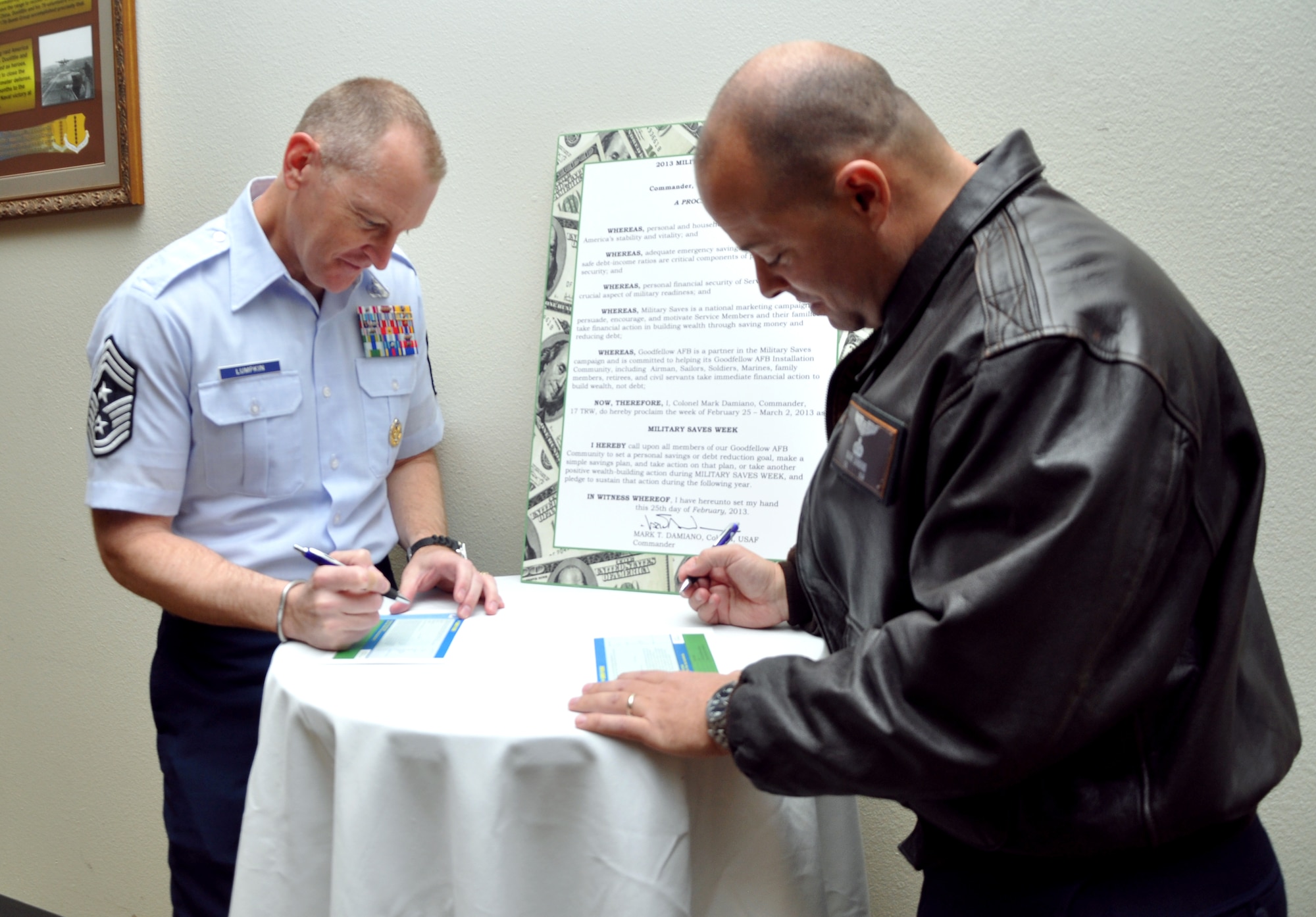 GOODFELLOW AIR FORCE BASE, Texas—Col. Mark Damiano, 17th Training Wing Commander, and Chief Master Sgt. Scott Lumpkin, 17th Training Wing Command Chief, each sign a pledge to save as part of the Military Saves Campaign kick-off at the Event Center, Feb. 25. The pledges are available to anyone at the Airman and Family Readiness Center and represent a dedication to save money. (U.S. Air Force photo/Airman Jessica Keith)  