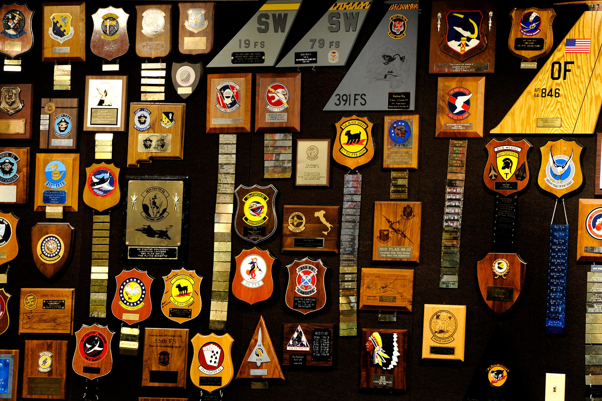 79th Fighter Squadron plaques are displayed among other unit plaques on the wall of the 414th Combat Training Squadron Red Flag auditorium, Feb. 22, 2013, Nellis Air Force Base, Nev. Fred Whitehead, 414th CTS database management, took on the project of organizing and displaying the plaques given to the Red Flag staff by units that have participated in previous Red Flag exercises. Among these mementos are 79th FS plaques dating back to the early 1990s. (U.S. Air Force photo by Staff Sgt. Kenny Holston\Released)