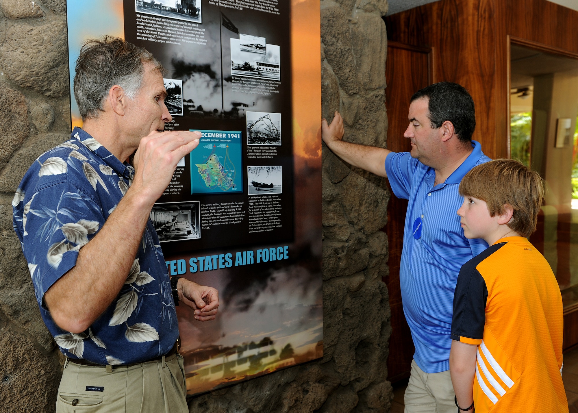 Charles Nicholls (left), Pacific Air Forces historian, explains how Japanese aircraft attacked on Dec. 7, 1941 to Carl Hess (right), Make-A-Wish recipient, and his father James Sullivan (center) at the Courtyard of Heroes, PACAF headquarters, Joint Base Pearl Harbor-Hickam, Hawaii, Feb. 19, 2013. Carl is fighting acute lymphoblastic leukemia (ALL), a fast-growing cancer of the white blood cells, and wished to be a downed World War II pilot. Since 1980, the MAW Foundation has changed the lives of children with life-threatening medical conditions through its wish-granting work. (U.S. Air Force photo/Tech. Sgt. Jerome S. Tayborn)