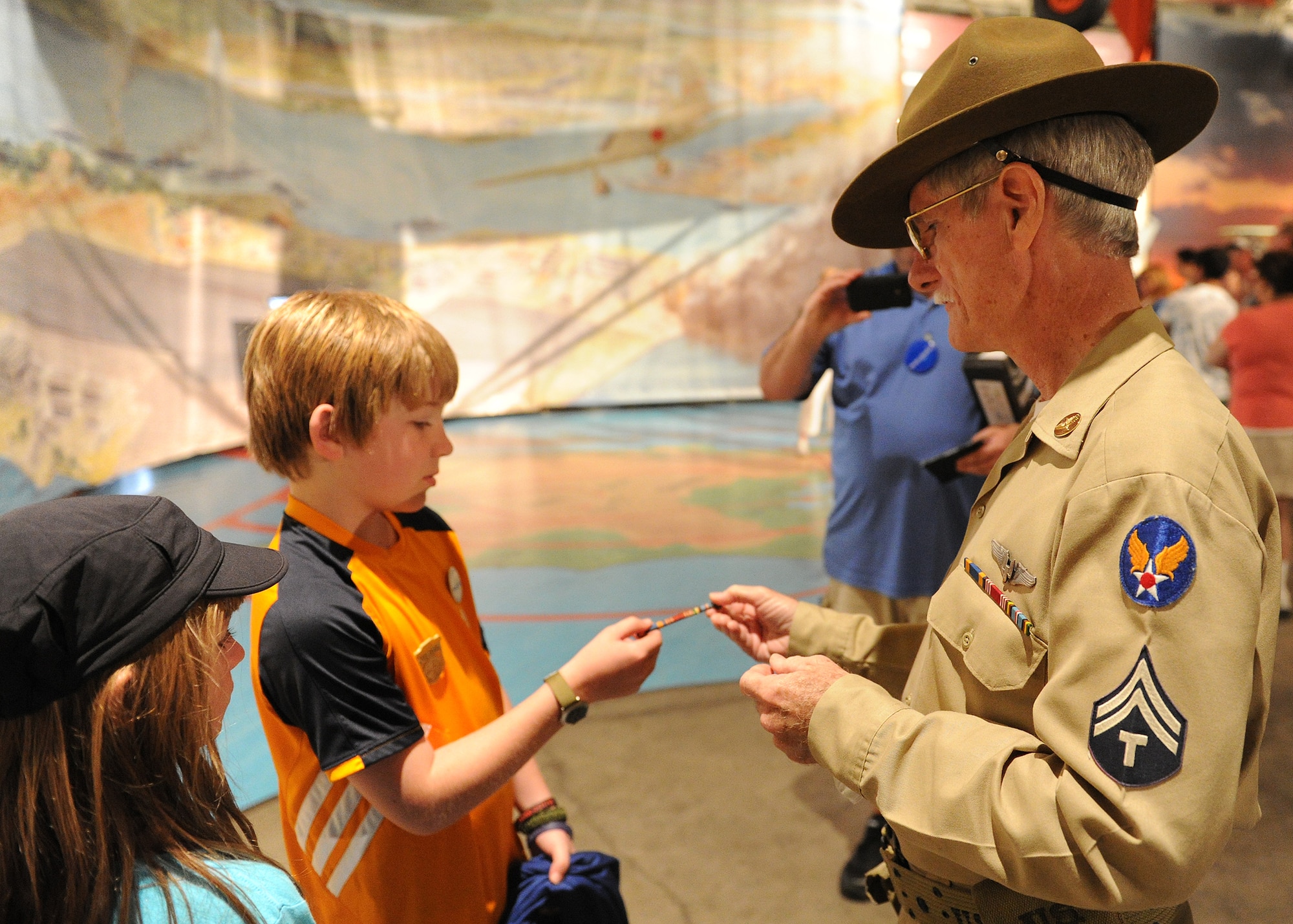 Carl Hess, Make-A-Wish recipient, receives an authentic World War II medal rack from Army Aviator (retired) Jerryl Stanfield at the Pacific Aviation Museum, Ford Island, Hawaii, Feb. 19, 2013. Carl is fighting acute lymphoblastic leukemia (ALL), a fast-growing cancer of the white blood cells, and wished to be a downed World War II pilot. During his visit he received a rare opportunity to spend the night aboard the USS Missouri, fly in a bi-plane, and tour various historical WWII sites. (U.S. Air Force photo/Tech. Sgt. Jerome S. Tayborn)