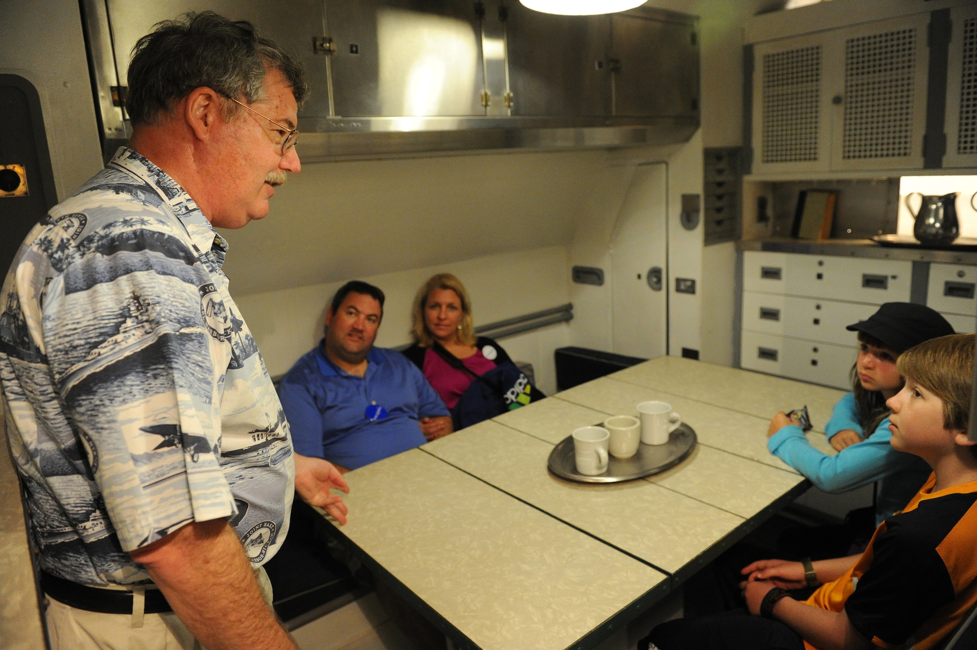 Charles Hinman, USS Bowfin, education director (left) explains the dinner menu in the galley of the USS Bowfin to Carl Hess, Make-A-Wish recipient, his sister Kayelynn Hess (right) and his parents James and Heidi Sullivan (center), near Ford Island, Hawaii, Feb. 19, 2013. Carl is fighting acute lymphoblastic leukemia (ALL), a fast-growing cancer of the white blood cells, and wished to be a downed World War II pilot. During his visit he received a rare opportunity to spend the night aboard the USS Missouri, fly in a bi-plane, and tour various historical WWII sites. (U.S. Air Force photo/Tech. Sgt. Jerome S. Tayborn)