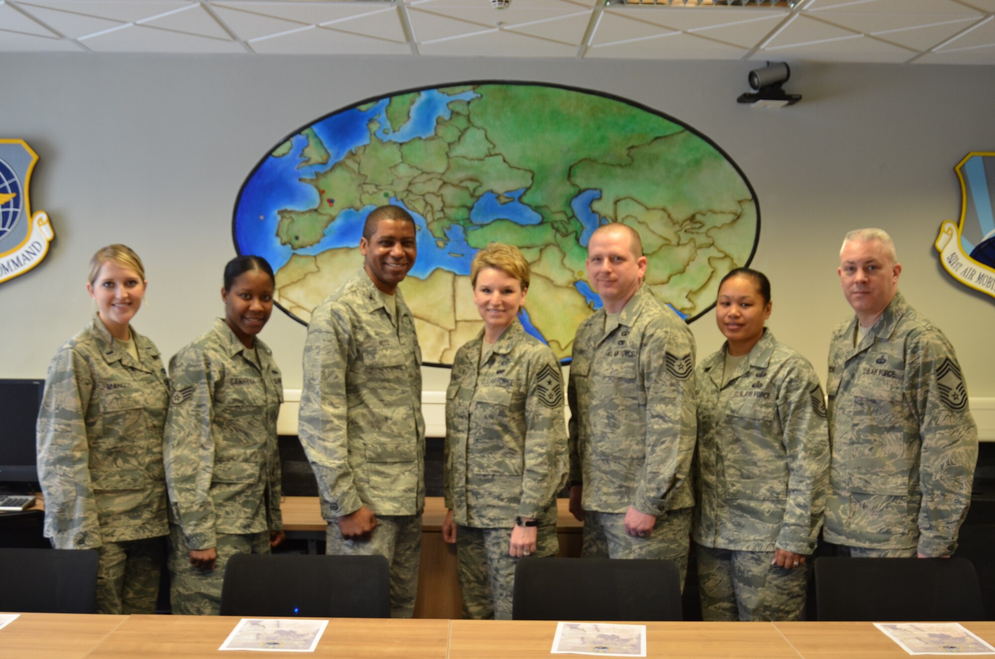 Members from the 521st Air Mobility Operations Wing pose for a picture in their newly completed heritage room at the Kisling NCO Academy on Kapaun Air Station, Germany, Feb. 15, 2013. The heritage room was completed by four volunteers from the 521st AMOW who had a commitment to their wing heritage and professional development. (U.S. Air Force photo / 2nd Lt. Kay M. Nissen)