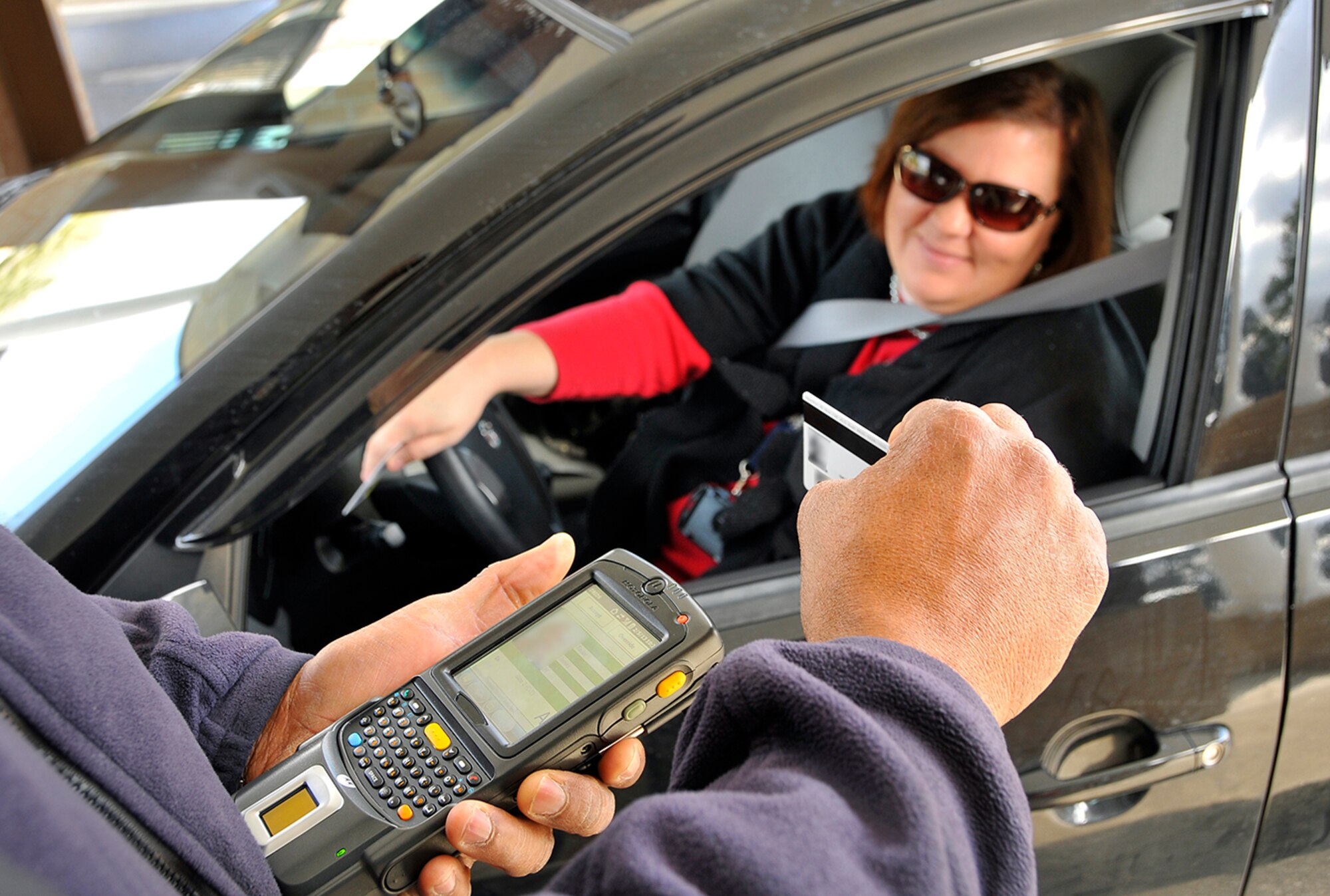 : Officer Jim Taylor operates the new Defense Biometric Identification System (DBIDS) as ATA employee MaryBeth Barlow enters the AEDC main gate. The DBIDS scans an individual’s Common Access Card (CAC) or similar DOD credentials when they enter the base security gates. (Photo by Jacqueline Cowan)