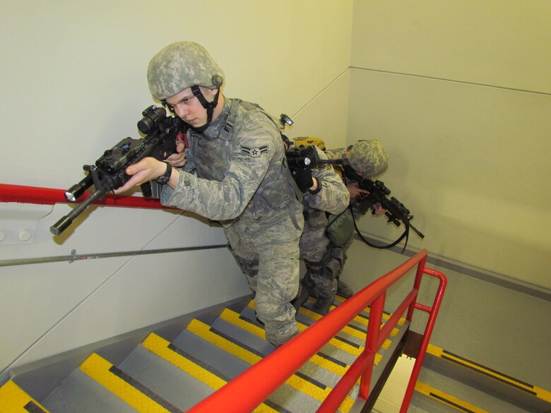 THULE AIR BASE, Greenland -- Senior Airman David Light and Airmen 1st Class Caleb Coates and Matthew Yoder clear a staircase during battle drills at Thule. Battle drills have allowed the Airmen to tailor training to a hands-on and mission specific approach to ready Airmen and heighten security measures. (U.S. Air Force photo)