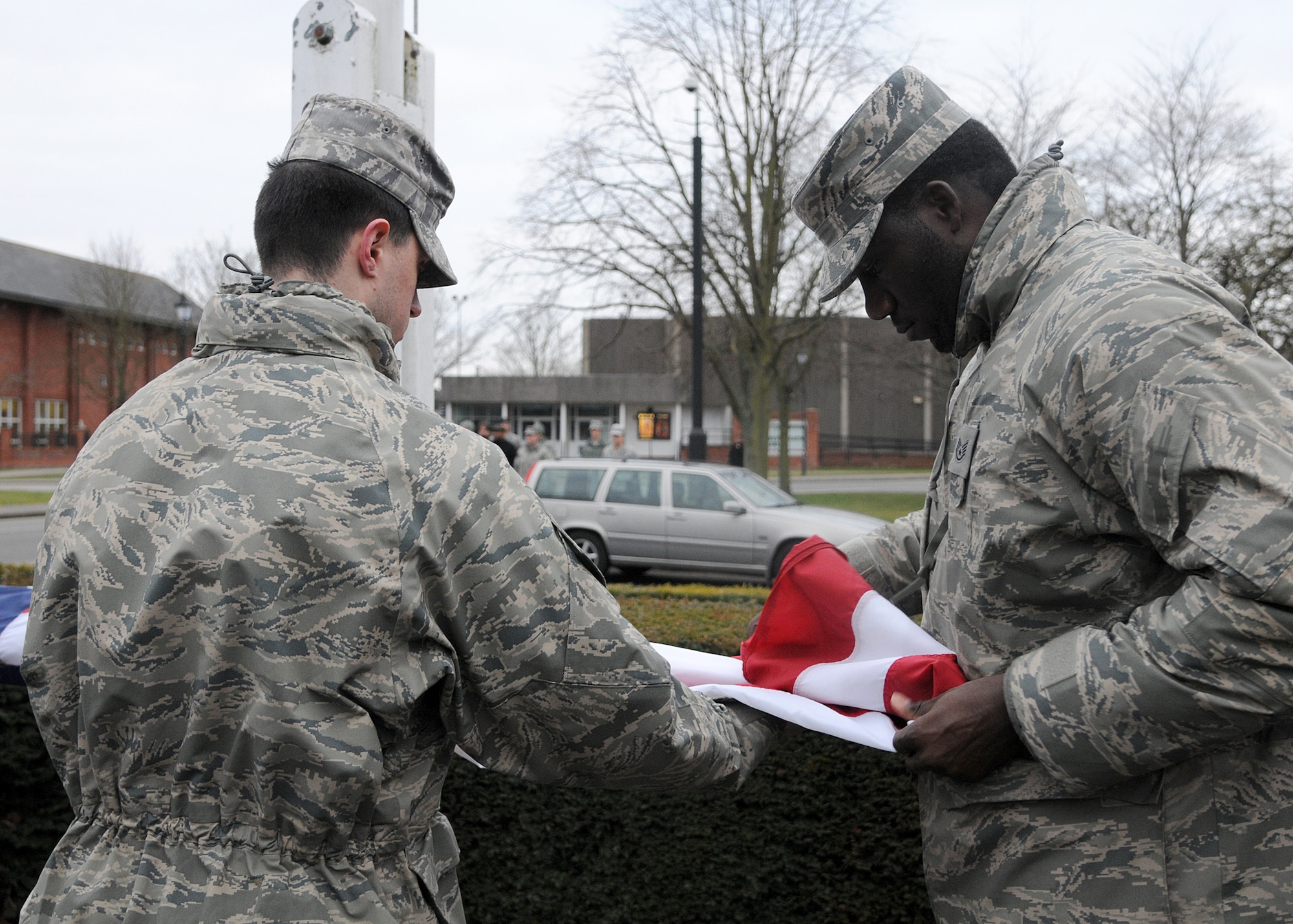 Airmen from the 100th Mission Support Group fold the American flag during a monthly retreat ceremony Feb. 22, 2013, at RAF Mildenhall, England. Retreat is a ceremony symbolizing the end of the duty day as well as paying respect to the flags. (U.S. Air Force photo by Airman 1st Class Kelsey Waters/Released)