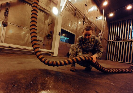 WHITEMAN AIR FORCE BASE, Mo. -- Senior Airman Kaitlyn Fawber, 509th Maintenance Squadron aerospace propulsion journeyman, moves the starter air hose of a B-2 Spirit engine, Feb. 13. The starter air hose supplies air to the engine so it can power up. (U.S. Air Force photo/Staff Sgt. Nick Wilson) (Released)
